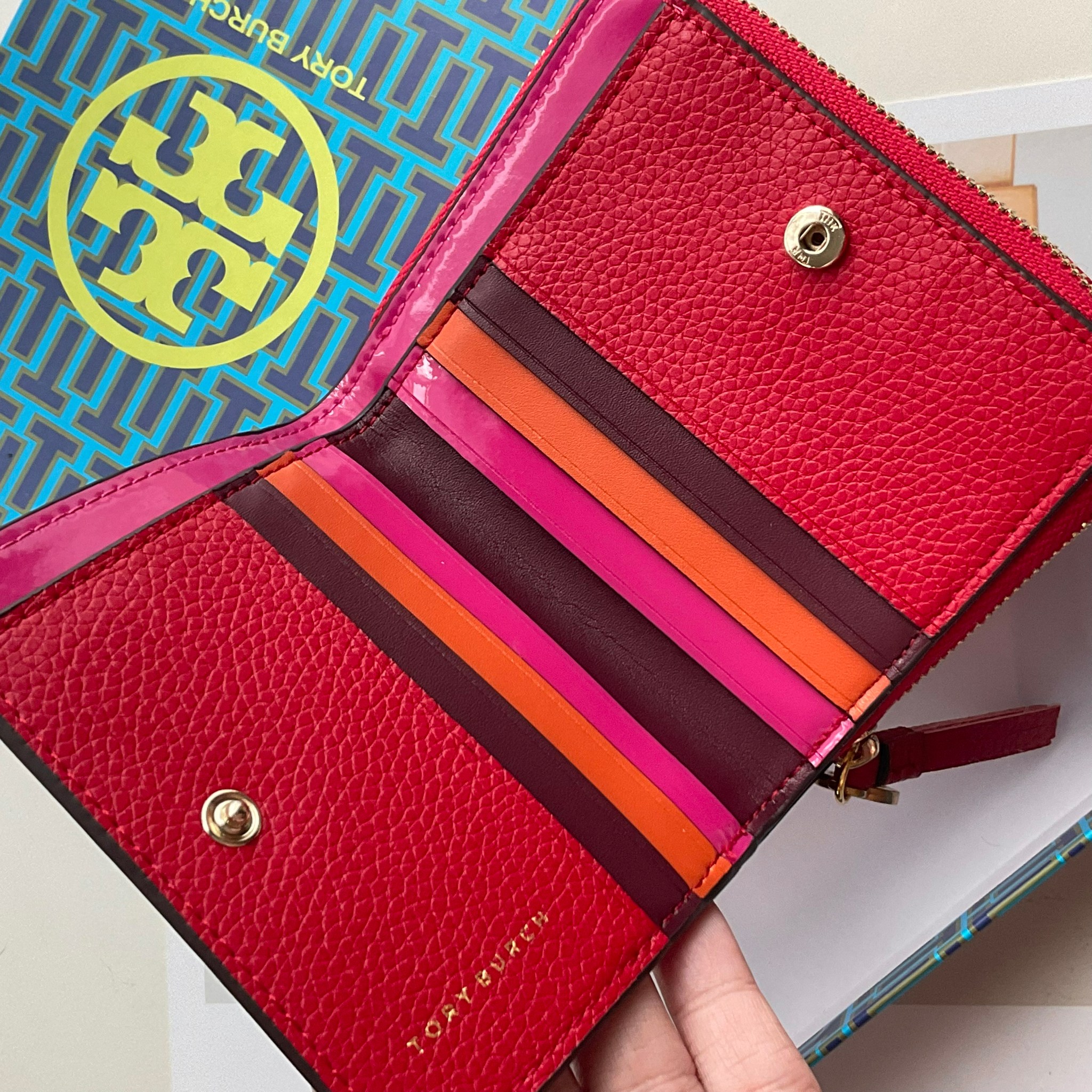 TORY BURCH LEATHER SMALL WALLET คอลเลคชั่นปีชวดจาก Tory มาในแบบกระเป๋าสตางค์ทรงสั้น เปิดใช้งาน2ด้าน มีทั้งด้านช่องซิปใส่เหรียญ และอีกด้านที่ใส่การ์ดได้มากถึง8ใบ มีช่องใส่ธนบัตร ภายในแต่งสี multi-color ดูมีสีสัน วัสดุ Simulation leather นิ่มสบายมือมีความเป