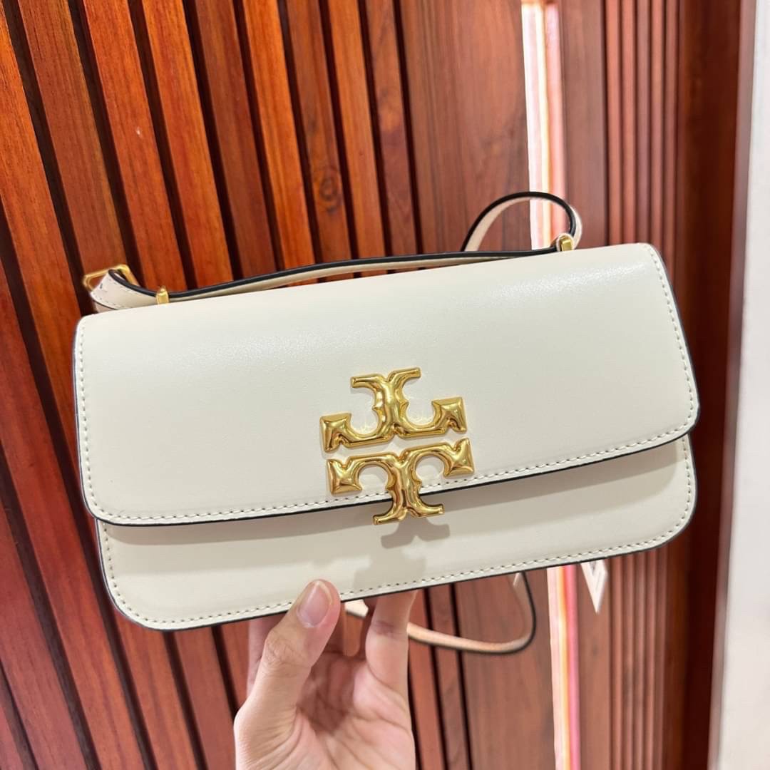 TORY BURCH ELEANOR SMALL LONG CONVERTIBLE SHOULDER กระเป๋าสะพายทรงยาว E/W Eleanor Convertible สูดหรู ดูแพง หนังแท้ เรียบสวยหรู โดดเด่นด้วยป้ายโลโก้สีทอง ลาย Double T อันเป็นเอกลักษณ์ ภายในช่องโล่งกว้างสามารถใส่โทรศัพท์ได้ทุกรุ่น สามารถใส่กระเป๋าสตางค์ใบยา