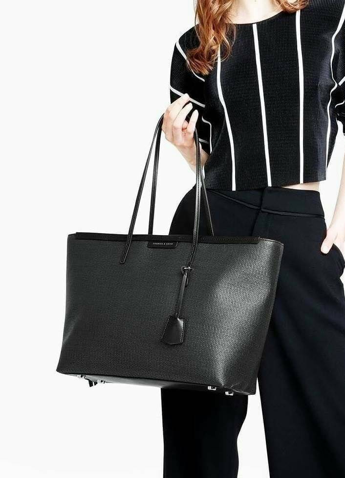 Charles & Keith Black Textured Tote Bag กระเป๋าสะพายทรง Shopping ใบใหญ่จุใจโดดเด่นด้วย Textured สานรอบใบสวยอยู่ทรง น้ำหนักเบา ด้านหน้ามีโลโก้พร้อมTAG พวงกุญแจห้อยที่หูหิ้ว เปิดปิดด้วยซิปพู่หนังสายยาว ภายในกว้างและจุ มีช่องใส่ของและช่องซิป ใส่เอกสารA4 ipad
