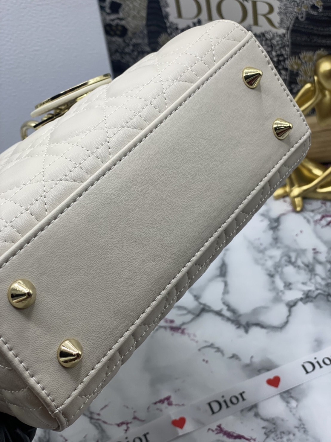 หนังแท้ DIOR LADY BAG 20cm ความสง่างามอีกหนึ่งรุ่นของ Dior รูปทรงสีเหลียม ขนาดกระทัดรัด ตั้งอยู่ทรง ฐานกระเป๋าแข็งแรง มีหมุดรองฐาน ดีไซน์ที่มีเอกลักษณ์เฉพาะตัว ด้านหน้าตกแต่งด้วยตัวอักษร D.I.R ห้อยเป็นพวงกุญแจ จะถือด้วยมือหรือสะพายไหล่ก็ดูดีมากๆ ค่ะ