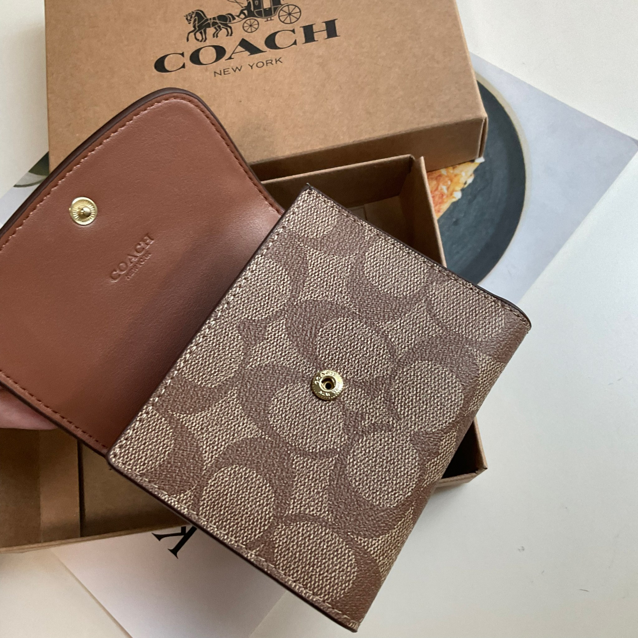 COACH SMALL WALLET IN SIGNATURE CANVAS กระเป๋าสตางค์ใบสั้น แบบพับสามตอน เปิดปิดด้วยกระดุมปั้มแบรนด์ ด้านในมีช่องใส่บัตรหลายช่อง และช่องใส่ธนบัตร ด้านหลังมีช่องซิปเหรียญอีกหนึ่งช่อง น้ำหนักเบา พกพาสะดวก อะไหล่เงาสุดหรู ห้ามพลาดค่ะ!