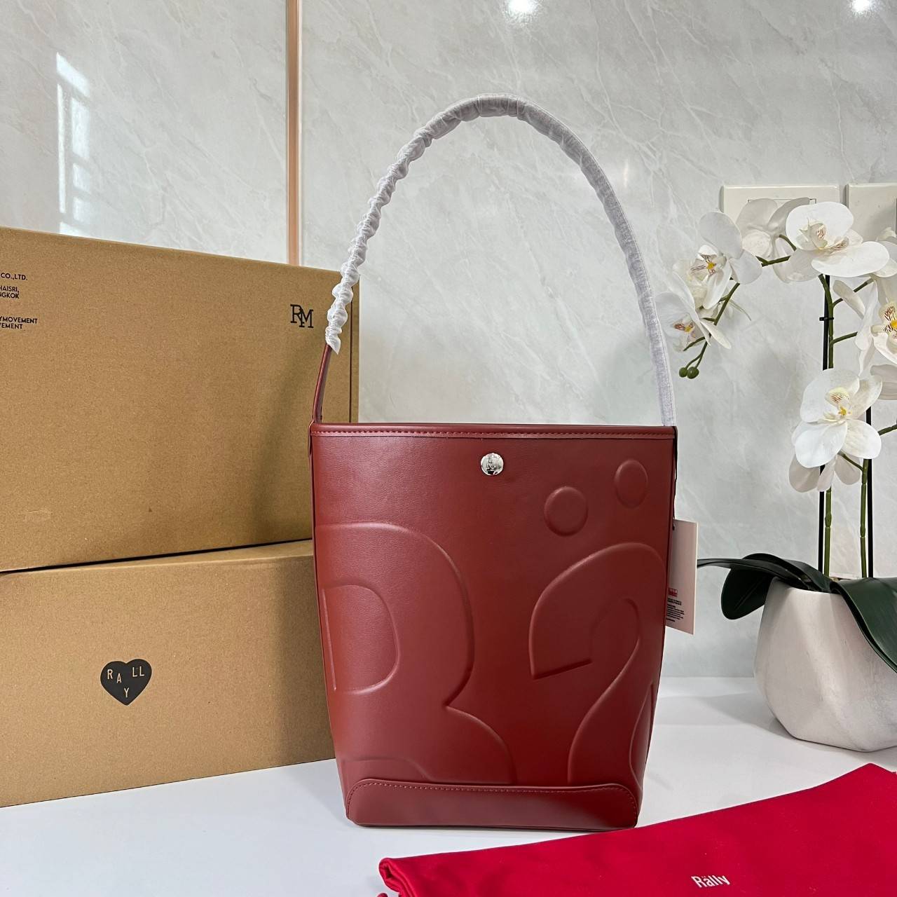 Rally The Bag Whisper กระเป๋าทรงบัคเก็ตงานหนังรุ่นใหม่ ฮอทติดลมบน มาแรงสะพายกันทั่วบ้านทั่วเมือง สายแบกสายขนห้ามพลาดจุของได้เยอะ รุ่นหนังผิวสัมผัสนิ่มมือ ทนทานและจุสิ่งของได้ครบครัน โดดเด่นด้วยโลโก้ตัวนูน