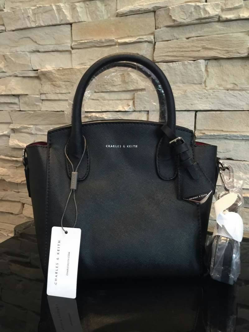 CHARLES & KEITH GUSSETED TOTE BAG กระเป๋าถือหรือสะพายวัสดุหนัง Saffiano สวยอยู่ทรงเเข็ง ไม่ย้วย ขนาดกำลังดี น้ำหนักเบา ดีไซน์สวยเก๋ด้วย TAG .ห้อยที่หูกระเป๋าปั๊มโลโก้แบรนด์อะไหล่ถอดเเยกใช้ได้ เปิดปิดด้วยซิปสะดวกใช้ สามารถใส่กระเป๋าสตางค์ใบยาว ของใช้จุกจิก