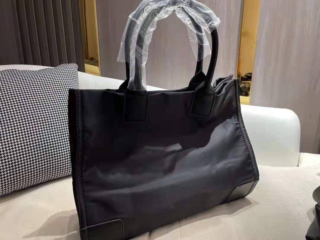 TORY BURCH ELLA TOTE BAG *BUY1GET1 สวยคุ้มในราคาสบายกระเป๋า‼️ กระเป๋าทรง SHOPPING วัสดุ NYLON ทั้งใบตัดด้วยหนัง SAFFIANO ดำ ตกแต่งด้วยหมุดรอบโลโก้แบรนด์ ด้านในบุผ้าปั้มแบรนด์ เปิดปิดด้วยกระดุมแม่เหล็ก ช่องกว้างหลักหนึ่งช่องและช่องซิปอีกช่อง พร้อมช่องใส่ขอ