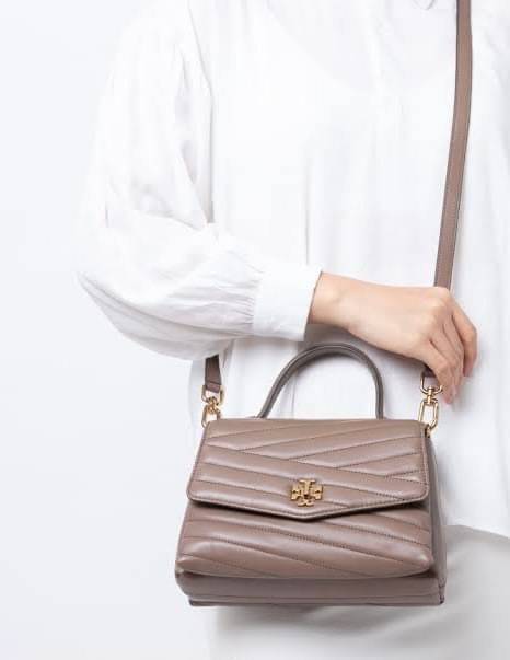 TORY BURCH Kira Chevron Top-handle Satchel กระเป๋าหนังแกะ สัมผัสนุ่มควบคู่กับดีไซน์อันเป็นเอกลักษณ์ กระเป๋าถือทรงสวยที่มีดีไซน์อันเป็นเอกลักษณ์ไม่เหมือนกับที่ไหน ด้วยการตัดเย็บหนังแกะแสนนุ่มแบบลายบุสองชั้น เพิ่มมูลค่าด้วยสายสะพายที่ทำจากโลหะสีทอง อีกทั้งย