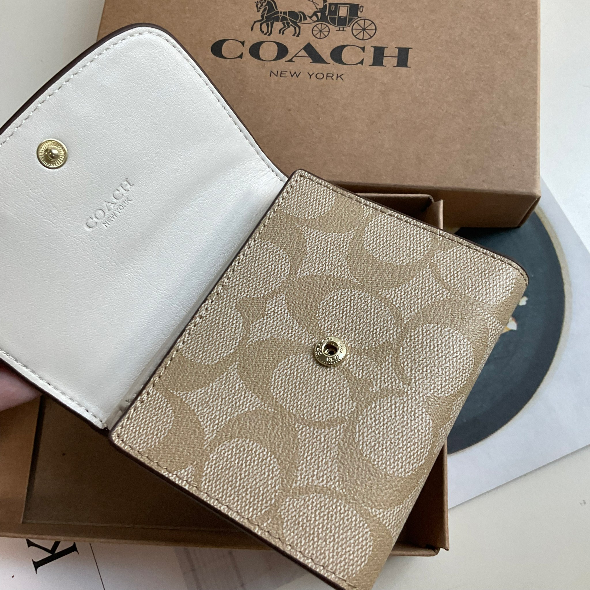 COACH SMALL WALLET IN SIGNATURE CANVAS กระเป๋าสตางค์ใบสั้น แบบพับสามตอน เปิดปิดด้วยกระดุมปั้มแบรนด์ ด้านในมีช่องใส่บัตรหลายช่อง และช่องใส่ธนบัตร ด้านหลังมีช่องซิปเหรียญอีกหนึ่งช่อง น้ำหนักเบา พกพาสะดวก อะไหล่เงาสุดหรู ห้ามพลาดค่ะ!