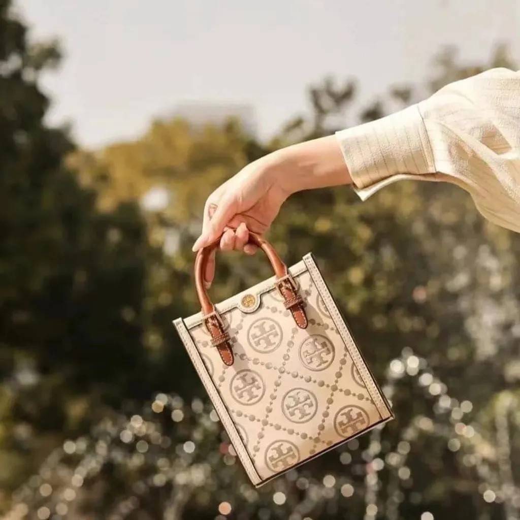 TORY BURCH T MONOGRAM EMBOSSED MINI TOTE สุดหรูกับกระเป๋าสะพายทรงโท้ท ไซส์มินิ ที่สร้างความหรูหราให้ตัวกระเป๋าด้วยดีเทลลายนูน แต่งแต้มลวดลายเอกลักษณ์ สีลูกคุณมากๆ!! วัสดุหนังแท้ ผิวสัมผัสดี ปากกระเป๋ามีแถบแม่เหล็กกันของหล่นได้ ภายในโล่ง ใส่ของจำเป็นได้ โท