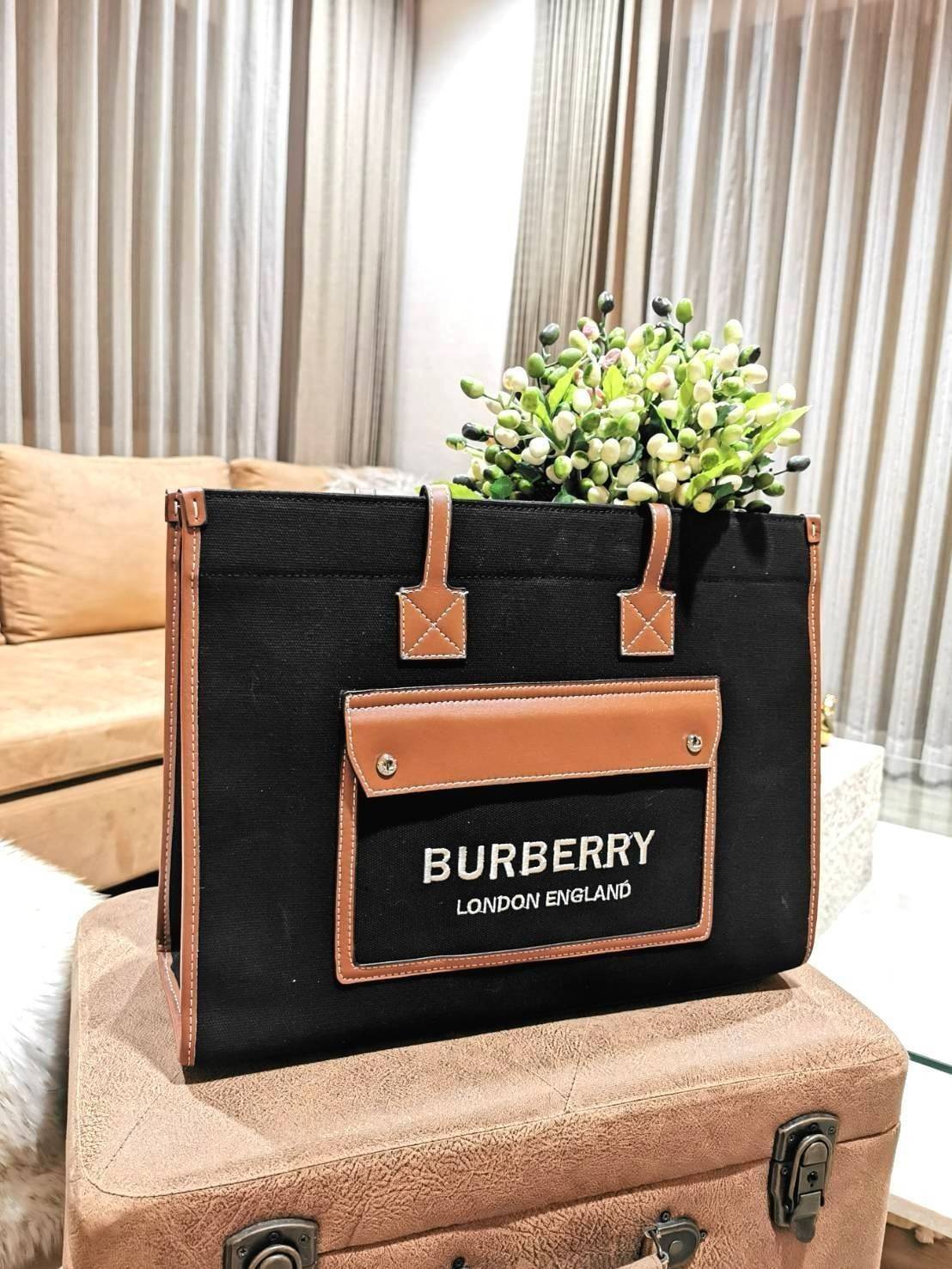 BURBERRY FRAGRANCES LARGE TOTE BAG วัสดุ Canvas & Leather ทรงเหลี่ยมมาในสี TwoTone ดีไซน์สวยอยู่ทรงสไตล์ Casual ด้านหน้ามีช่องใส่ของ ภายในโล่งกว้างและจุสุดๆสามารถใส่เอกสารA4 หนังสือ ของใช้ได้เยอะ น้ำหนักเบา อะไหล่แบรนด์สีทองหรู หูหิ้วหนังสะพายไหล่ได้ พร้อ