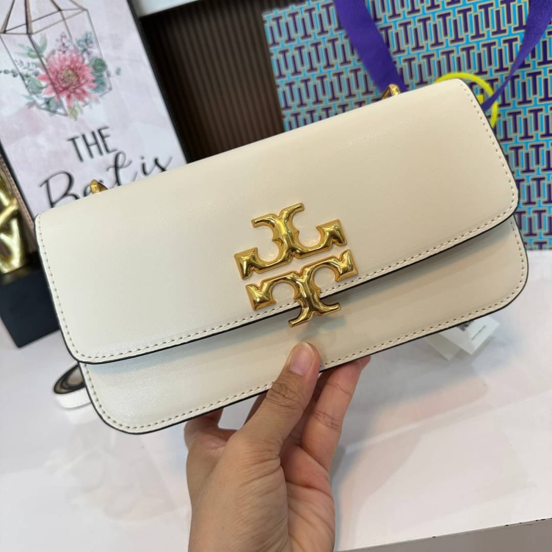 TORY BURCH ELEANOR SMALL LONG CONVERTIBLE SHOULDER กระเป๋าสะพายทรงยาว E/W Eleanor Convertible สูดหรู ดูแพง หนังแท้ เรียบสวยหรู โดดเด่นด้วยป้ายโลโก้สีทอง ลาย Double T อันเป็นเอกลักษณ์ ภายในช่องโล่งกว้างสามารถใส่โทรศัพท์ได้ทุกรุ่น สามารถใส่กระเป๋าสตางค์ใบยา