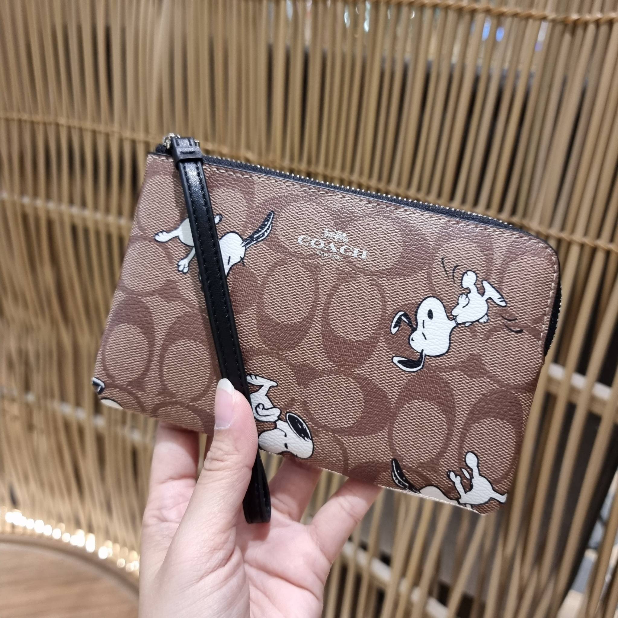 COACH C4589 COACH x PEANUTS CORNER ZIP WRISTLET IN SIGNATURE CANVAS WITH SNOOPY PRINT เหล่าผองเพื่อนและสนูปพีมาแล้วจ้า คอลเลคชั่นสุดน่ารักที่ฮอตไม่มีตก กระเป๋าคล้องมือ ขนาดเหมาะพกพากำลังเหมาะ วัสดุหนังแคนวาสเคลือบลาย ภายในเป็นช่องโล่ง ใส่ธนบัตร หรือใส่บัต