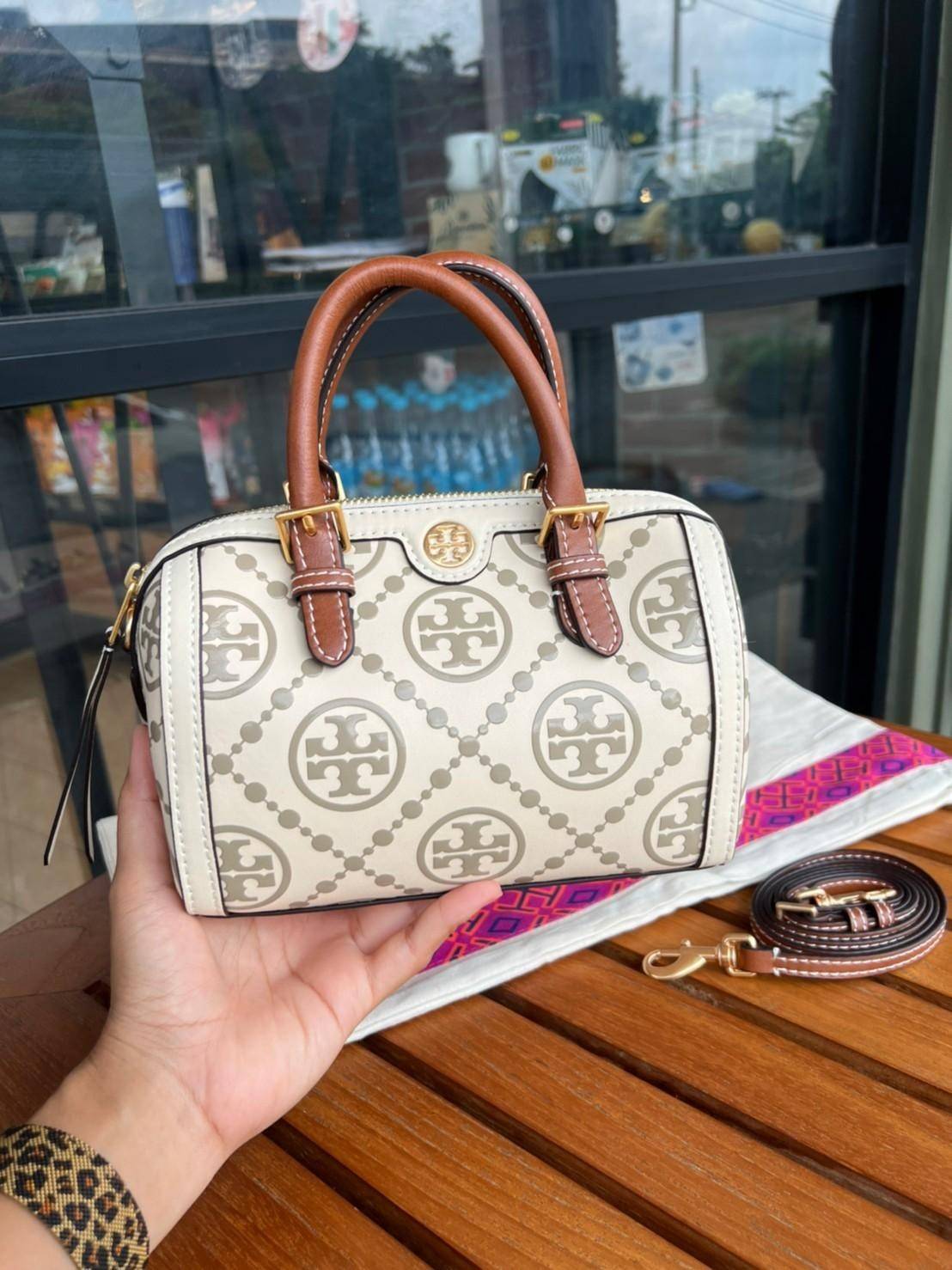 Tory Burch T-Monogram Mini Embossed Wine Bucket Bag / Tory Burch Mini Bucket กระเป๋าถือหรือสะพายไหล่ ทรงหมอนขนาดเล็ก ประดับด้วยลวดลายอันเป็นสัญลักษณ์ของแบรนด์ ถูกประดิษขึ้นด้วยความพิถีพิถันวัสดุหนังอย่างดี ด้านในบุด้วยหนังไมโครซูแอคเนื้อนุ่มทำความสะอาดง่า