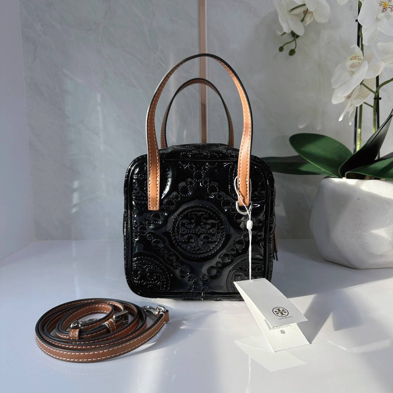 Tory Burch T Monogram Embroidered Patent Cube คอลเลคชั่นใหม่ รุ่นลิมิเต็ดรูปทรงใหม่ T Monogram สุดcube วัสดุหนังแท้ เปิด-ปิดด้วยซิป ภายในกว้าง มีช่องแยก 1 ช่อง สามารถใส่โทรศัพท์มือถือได้ทุกรุ่น สามารถถือหิ้วหรือสะพายได้ สายสามารถถอดและปรับระดับได้คะ