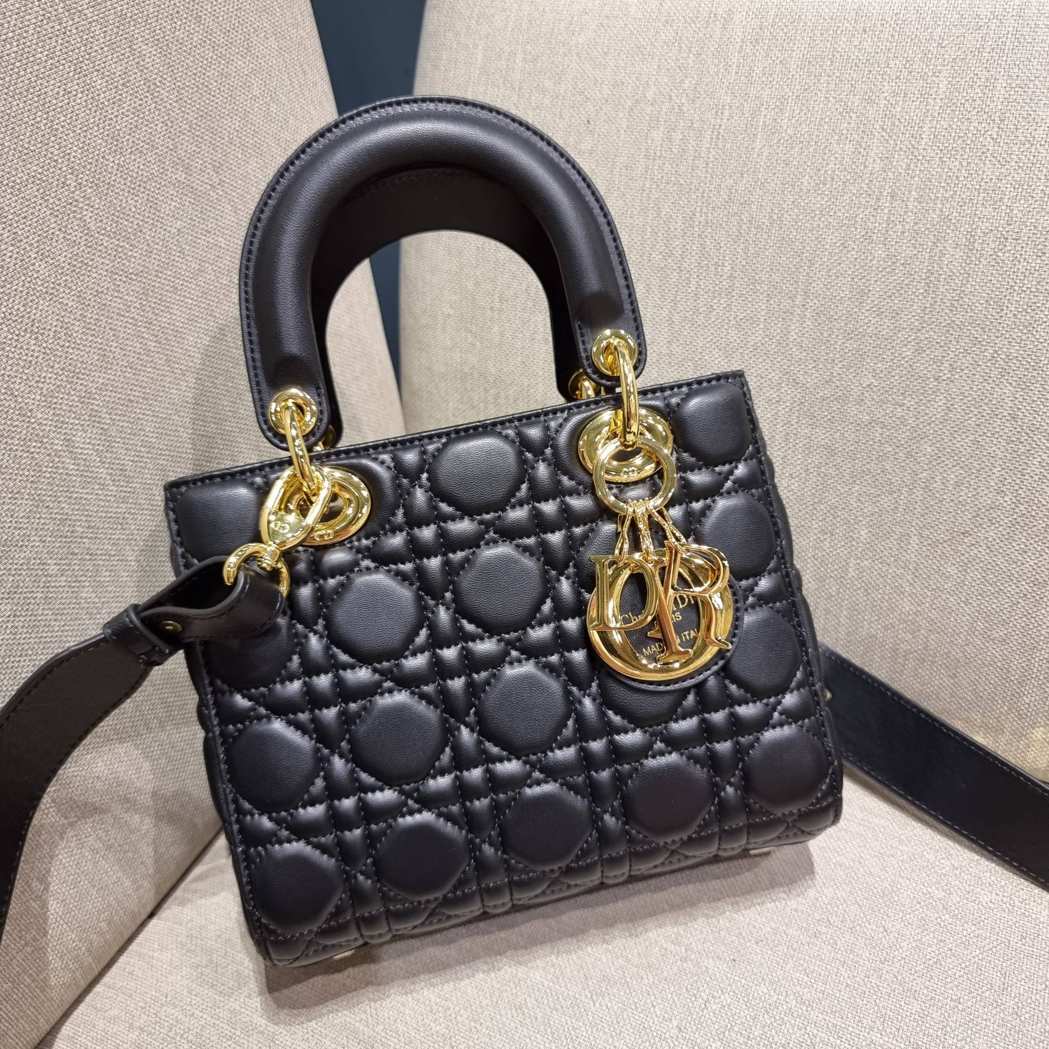 DIOR CD LADY BAG กระเป๋าสะพายข้างพรีเมี่ยมกิ๊ฟสุดฮอต ดีไซน์เรียบง่าย แต่แฝงไปด้วยความหรูหรา ทรงกล่องคลาสสิค โดดเด่นด้วยพวงกุญแจอะไหล่สีทอง วัสดุหนังแท้ มีหูจับในตัวและสายครอสบอดี้สุดเลิศ ที่มาพร้อมอะไหล่ฟอนท์สีทองเรียงร้อยในสายหนัง แต่งเติมดีเทลอัพราคาไปอ