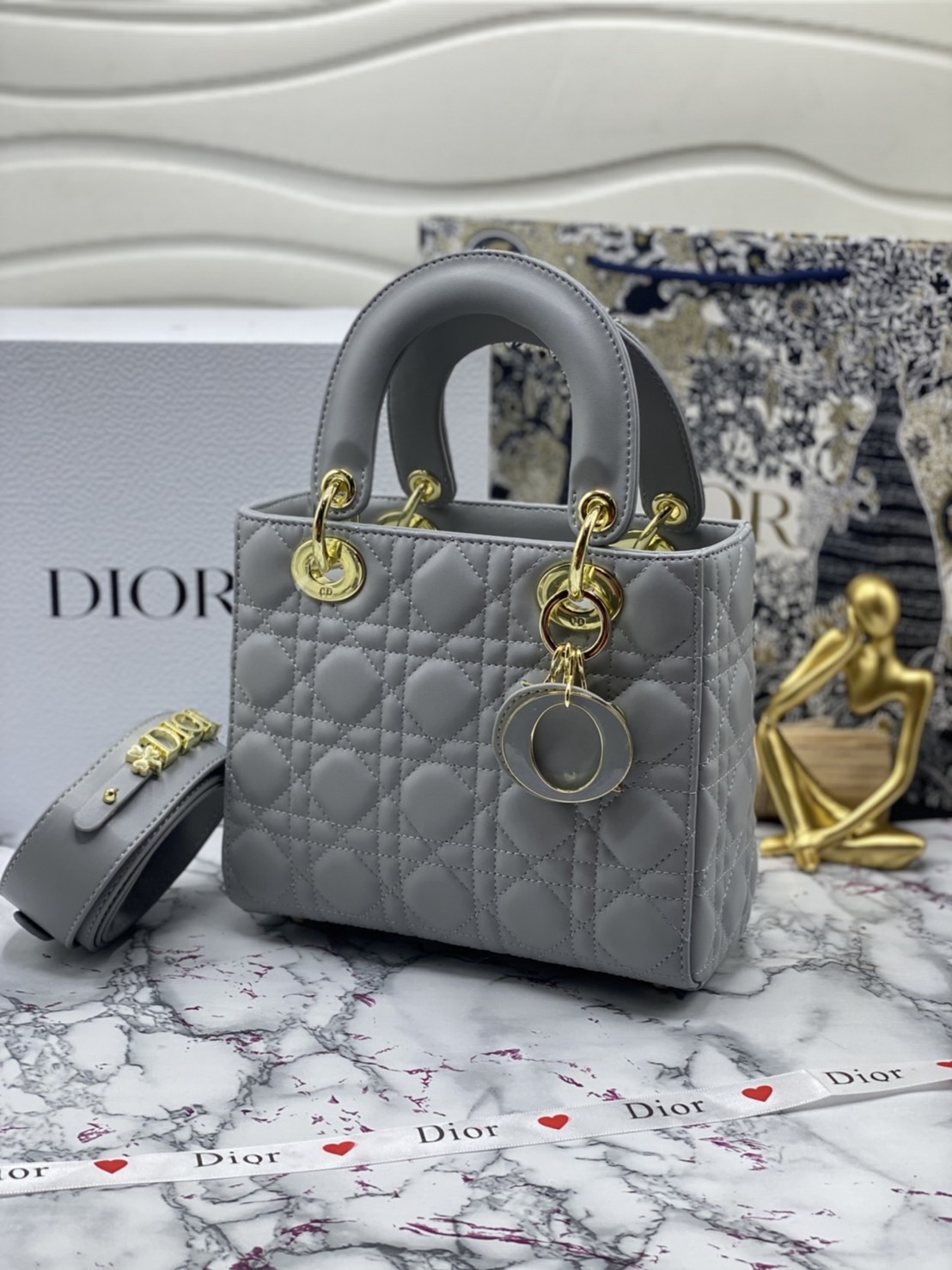 หนังแท้ DIOR LADY BAG 20cm ความสง่างามอีกหนึ่งรุ่นของ Dior รูปทรงสีเหลียม ขนาดกระทัดรัด ตั้งอยู่ทรง ฐานกระเป๋าแข็งแรง มีหมุดรองฐาน ดีไซน์ที่มีเอกลักษณ์เฉพาะตัว ด้านหน้าตกแต่งด้วยตัวอักษร D.I.R ห้อยเป็นพวงกุญแจ จะถือด้วยมือหรือสะพายไหล่ก็ดูดีมากๆ ค่ะ