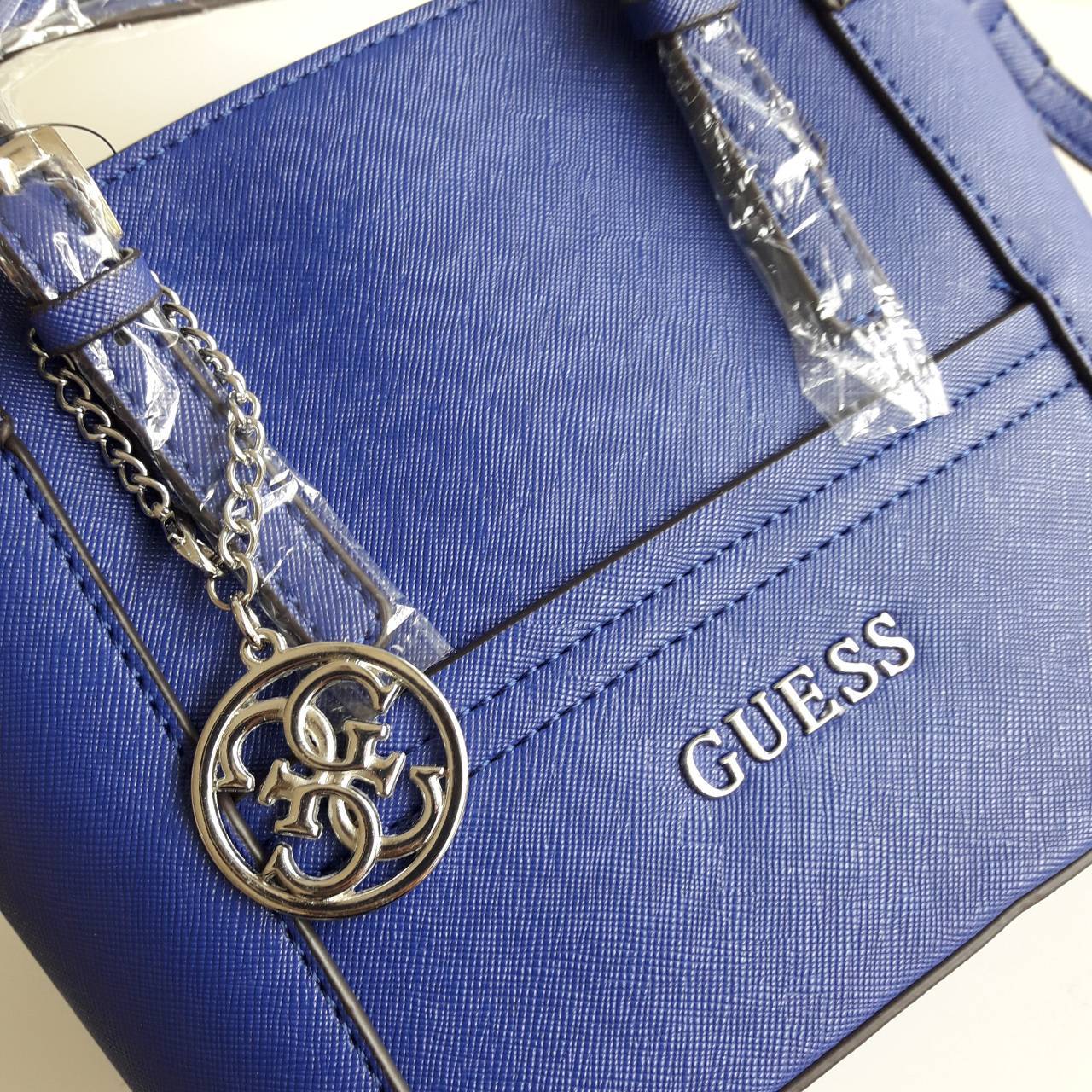 New! guess mini tote saffiano bag ลายหนัง Saffiano สวยอยู่ทรงสไตล์ PRADA ขนาดกำลังดีน้ำหนักเบา ด้านหน้าประดับโลโก้แบร์น พร้อมพวงกุญแจโลโก้แบรนด์ห้อยที่หูกระเป๋าสามารถถอดเเยกใช้ได้ เปิดปิดด้วยซิปสะดวกใช้ ภายในมีโลโก้ ช่องซิปและช่องเล็กใส่มือถือ ซับในพิมโลโ