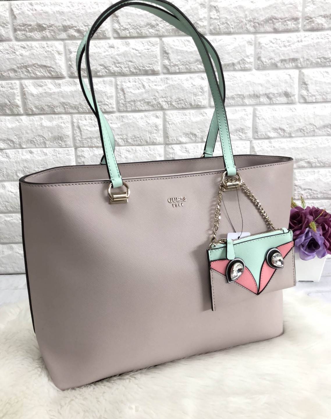 New GUESS WOMEN’S TOTE BAG 2018 พร้อมส่งรุ่นหายาก กระเป๋าถือทรง tote ลายหนัง safiano ด้านหน้าห้อยกระเป๋าใบเล็กดูหรูมากค่ะ สามารถถอดแยกมาใช้ได้ เปิดปิดกระเป๋าแบบกระดุมแม่เหล็ก ภายในโล่งกว้าง ใส่ของจุ มีช่องซิปและช่องเล็กใส่ของจุกจิกด้านหลังมีช่องซิปยาวหนึ่