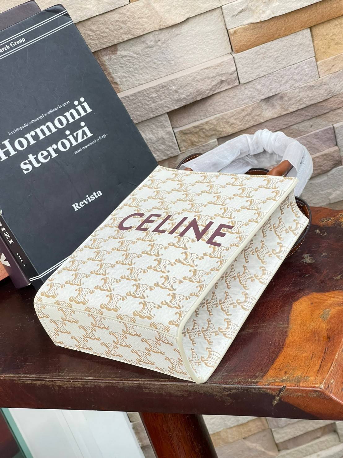 CELINE MINI VERTICAL CABAS IN TRIOMPHE CANVAS มีโลโก้ CELINE สกรีนอยู่ตรงกลาง ถือเป็นกระเป๋า Tote ที่ทำจากแคนวาสที่น่าสนใจมาก ๆ อีกรุ่นหนึ่ง และเป็นรุ่นที่ได้รับคำชื่นชมจากแฟชั่นกูรูทั้งหลายอีกด้วย หากใครที่อยากเป็นเจ้าของกระเป๋า Tote จาก CELINE สักใบ รุ่