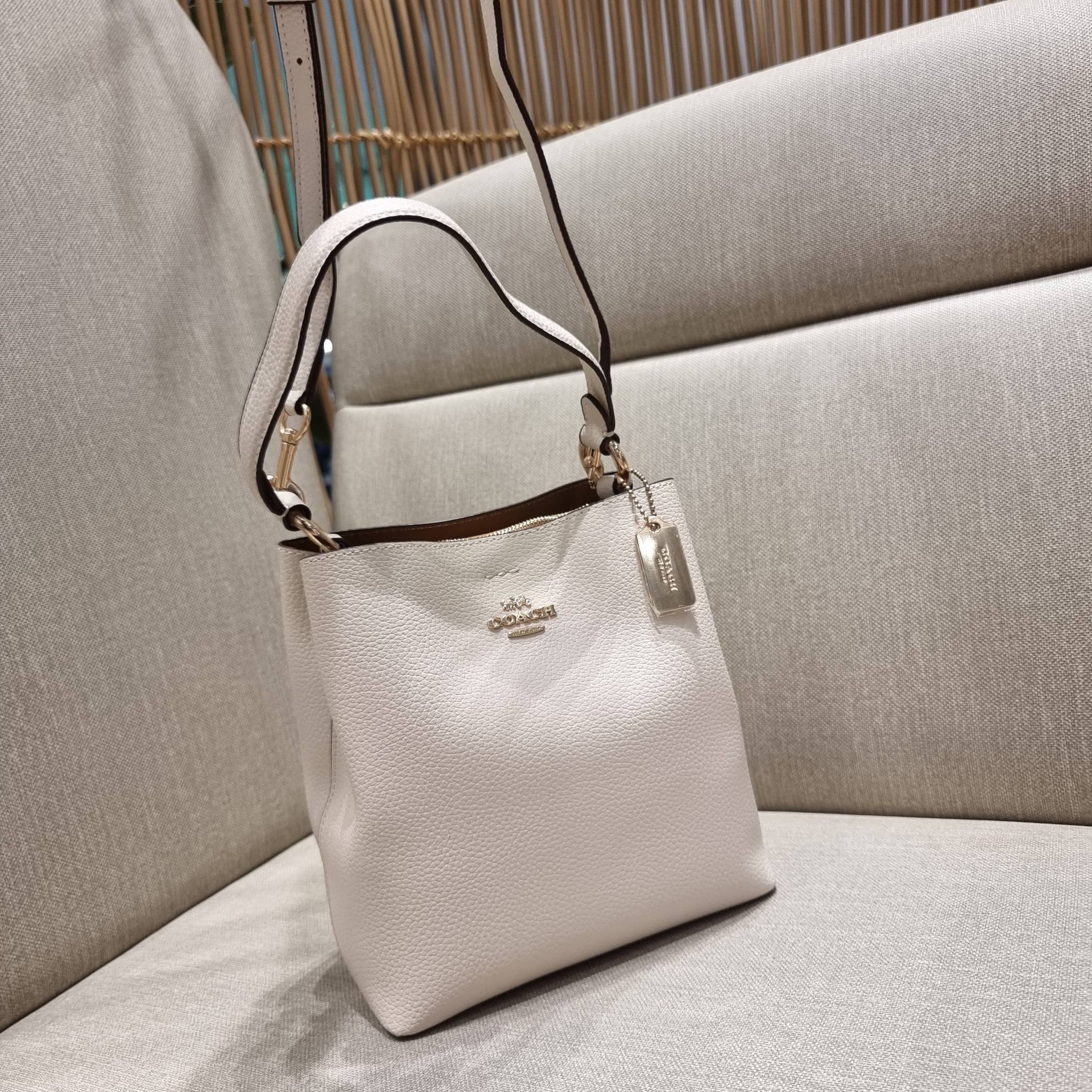 COACH 1011 SMALL TOWN BUCKET BAG รุ่นยอดนิยมใบเล็ก กระเป๋าทรงบัคเก็ต สีคลาสสิคเรียบหรู ตัดกับโลโก้สีทองดูโดดเด่น วัสดุหนัง pepble สวยคมทุกมุมจริงๆ!! เปิด-ปิดด้วยกระดุมแม่เหล็กทั้ง 2 ฝั่ง ภายในเป็นช่องโล่ง มาพร้อมสายสะพายปรับได้ตามตัว ขนาดใบนี้กำลังสวย สะพ
