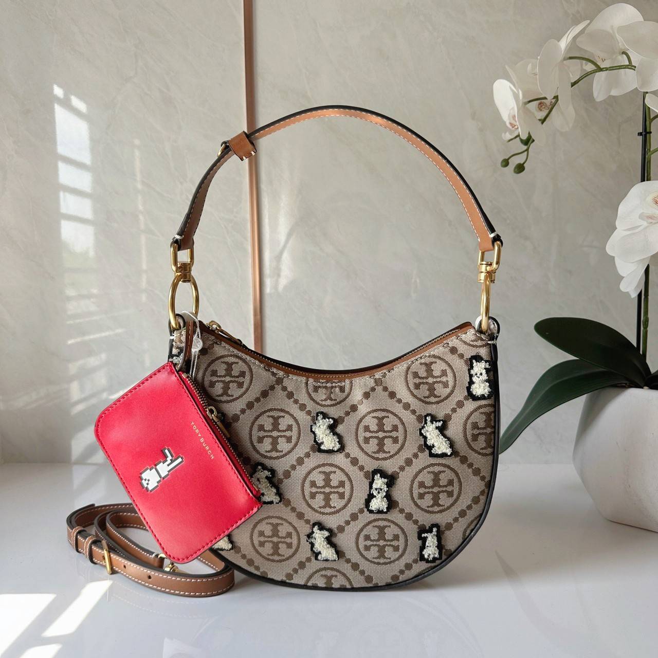 TORY BURCH Mini T Monogram Embroidered Rabbit Crescent Bag 🐇 คอลเลคชั่นกระต่ายสุดร้อนแรงแห่งปี 🥕🥕 คอลเลคชั่นทีบ่งบอกสไตล์ที่ทันสมัยทรงครึ่งวงปักลายกระต่ายบนกระเป๋าสุดน่ารัก โด่ดเด่น