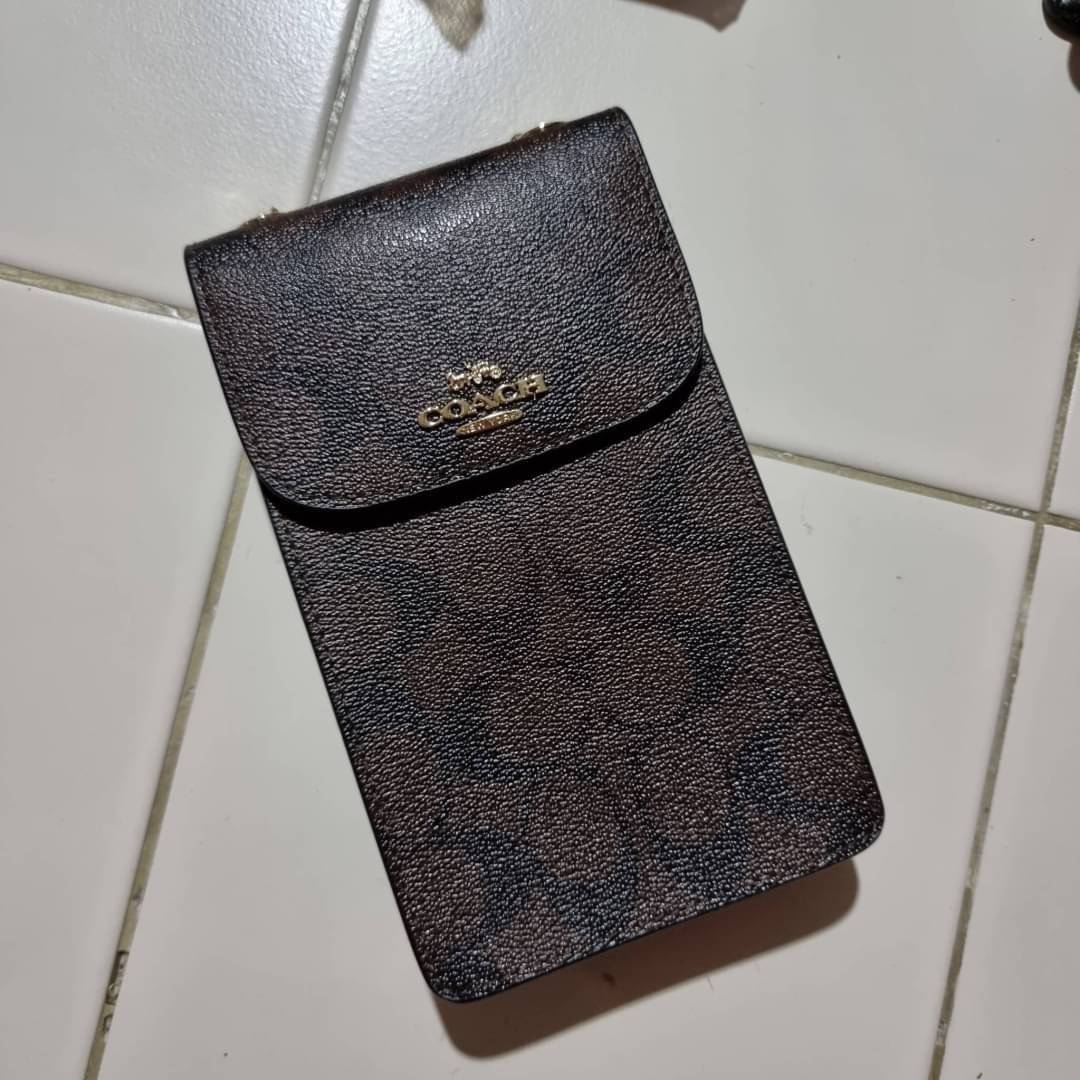 COACH NORTH/SOUTH PHONE CROSSBODY IN SIGNATURE CANVAS F55636 F39955 สุดคลาสสิคกับกระเป๋าสะพายเอนกประสงค์ Case phone ใส่โทรศัพท์มือถือได้ทุกรุ่น ดีไซน์ลายเอกลักษณ์ วัสดุหนังแคนวาสเคลือบลาย ฝาและภายในเป็นหนังสังเคราะห์เรียบ เปิด-ปิดด้วยกระดุม สายสะพายยาวประ