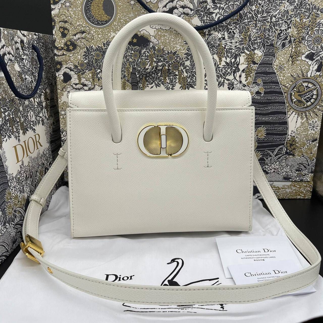 หนังแท้ DIOR Medium ST Honore Tote Collection Fall/Winter 2020-2021 มาในรูปแบบกระเป๋าทรงสี่เหลี่ยมที่ได้มาตรฐาน ทำจากหนังลูกวัว (Calfskin) ลายเกรน ซึ่งสื่อถึงความหรูหราได้อย่างลงตัว ตัวด้ามจับ มีการเย็บเข้าด้านในของกระเป๋าเพื่อเพิ่มความแข็งแรงทนทาน ด้านหน