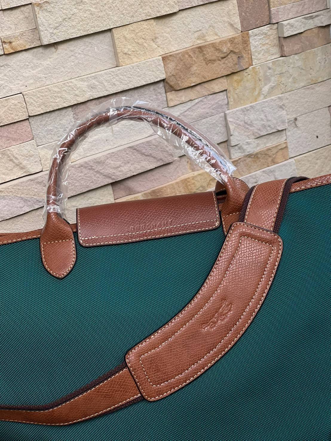 LONGCHAMP BOXFORD TRAVEL BAG L กระเป๋าเดินทางขนาดใหญ่ มาพร้อมสายสะพายที่สามารถถอดได้ ให้คุณเลือกสะพายไหล่หรือถือได้ มีซิปรูดเปิดปิดกระเป๋าที่ให้คุณมั่นใจได้ว่าคุณจัดเก็บไอเท็มของคุณได้อย่างมิดชิด บ็อคฟอร์ด (BOXFORD) สะท้อนความเป็นเอกลักษณ์ของแบรนด์ที่เปี่