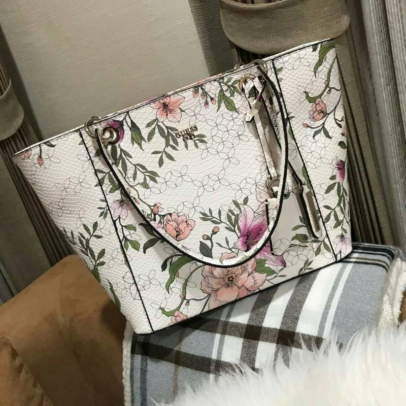 GUESS PRINTED KAMRYN FLOWERS SHOPPER BAG (SIZE L) กระเป๋าสะพายจาก GUESS FACTORY หนังสวยอยู่ทรงปริ้นลายดอกไม้คอลเลคชั่นล่าสุดใบใหญ่กำลังดี ใส่สัมภาระได้จุใจ น้ำหนักเบา ด้านหน้าประดับโลโก้แบรนด์อะไหล่เงินพร้อมพวงกุญแจแบรนด์ห้อยที่หูหิ้วถอดเเยกใช้ได้ หูหิ้วพ