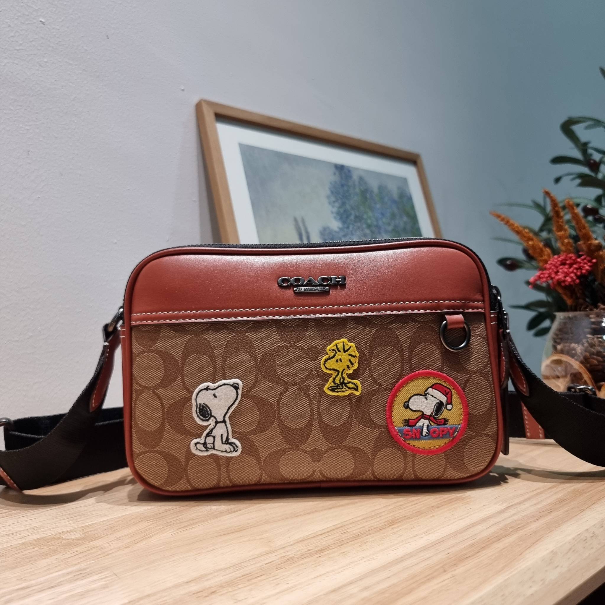 Coach X Peanuts Graham Crossbody In Signature Canvas With Patches CE746 กระเป๋าครอสบอดี้ทรงยอดฮิต กับคอลเลคชั่นใหม่ เฉลิมฉลองเทศกาลคริสต์มาส รุ่นนี้สามารถใช้ยูนิเซ็กส์ สาวๆหนุ่มๆได้หมด น่ารักน่าใช้เกิน!! รูปทรงดีไซน์คลาสสิค สีสันโดดเด่นสดใส ใช้งานสะดวก วั