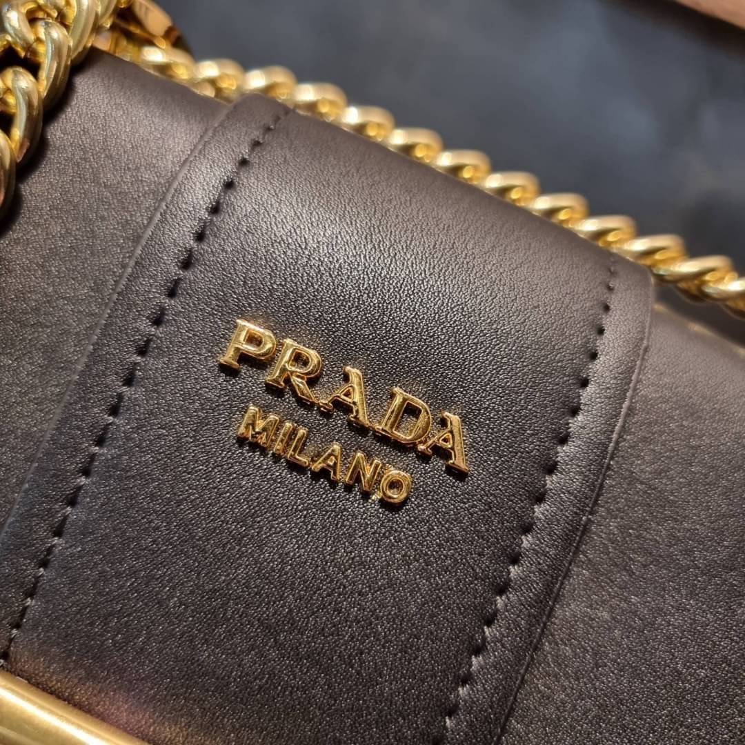 PRADA FRAGRANCE SHOULDER BAG WITH GWP ไอเท็มสุดโปรดที่ควรค่าแก่การครอบครองและเก็บสะสม กระเป๋าสะพายไหล่ สวยคม สีดำคลาสสิคตัดกับอะไหล่ทองเป็นอย่างดี วัสดุหนังแท้เต็มใบ เปิดปิดด้วยแถบหนังสอดในช่อง ใช้งานสะดวก พกพาง่าย ขนาดกำลังสวย สายสะพายในตัว สะพายได้หลากห