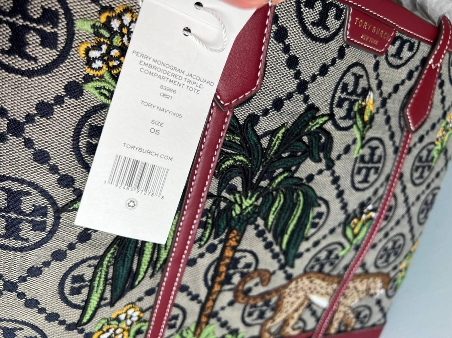 Tory Perry Embroidered T Monogram Triple Compartment Tote Bag เป็นแพทเทิร์นที่ได้รับแรงบันดาลใจจากการควิลท์สไตล์เพนซิลเวเนียดัตซ์ดั้งเดิมและเฉลิมฉลองโลโก้อันเป็นสัญลักษณ์ของแบรนด์ วัสดุผ้าแจ็คการ์ดแบบทอหนัง อะไหล่ทอง โดดเด่นด้วยลายเสือชีร์ต้าร์ งานเย็บปัก