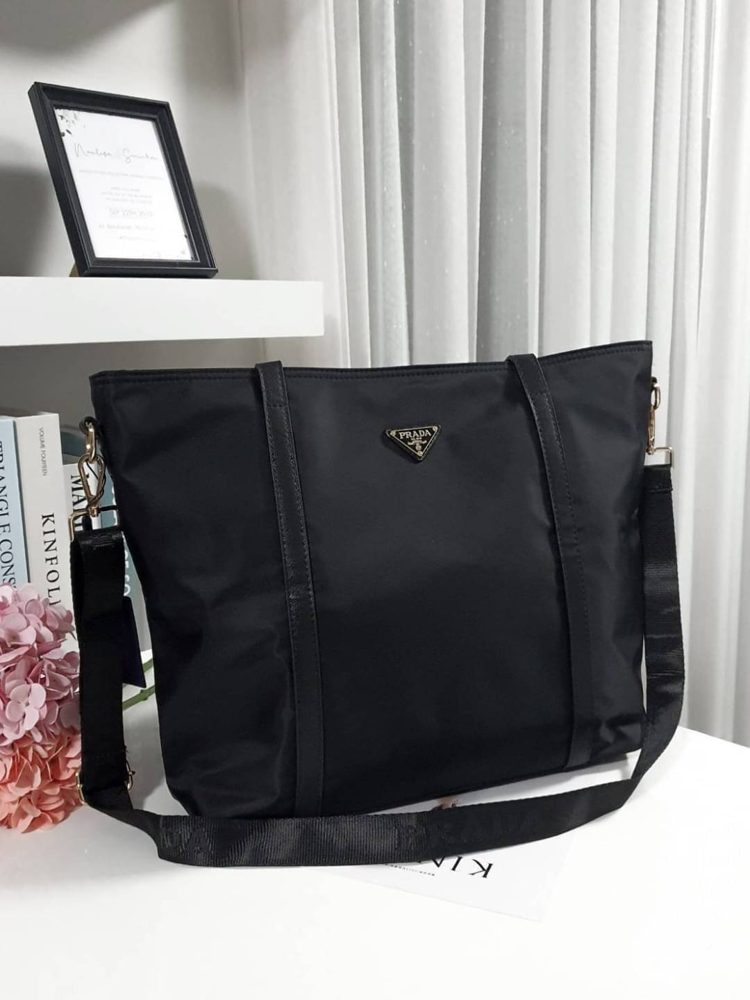 งานใบใหญ่ จากงานพรีเมี่ยมกิ้ฟ จากเคาเตอร์ต่างประเทศคะ แบรนด์ PRADA เป็น กระเป๋าผ้าไนล่อน ตามแบบฉบับของแบรนด์เลย หลงรักเลยคะ สะพายไหล่ได้ ถือก็สวยๆ ใช้แล้วสวยมากๆ มาพร้อมสายสะพายยาว ใส่ของได้เยอะเว่อร์ IPAD สมุด หนังสือ ขวดน้ำ ใส่ได้สบาย คุ้มราคามากคะ ห้าม