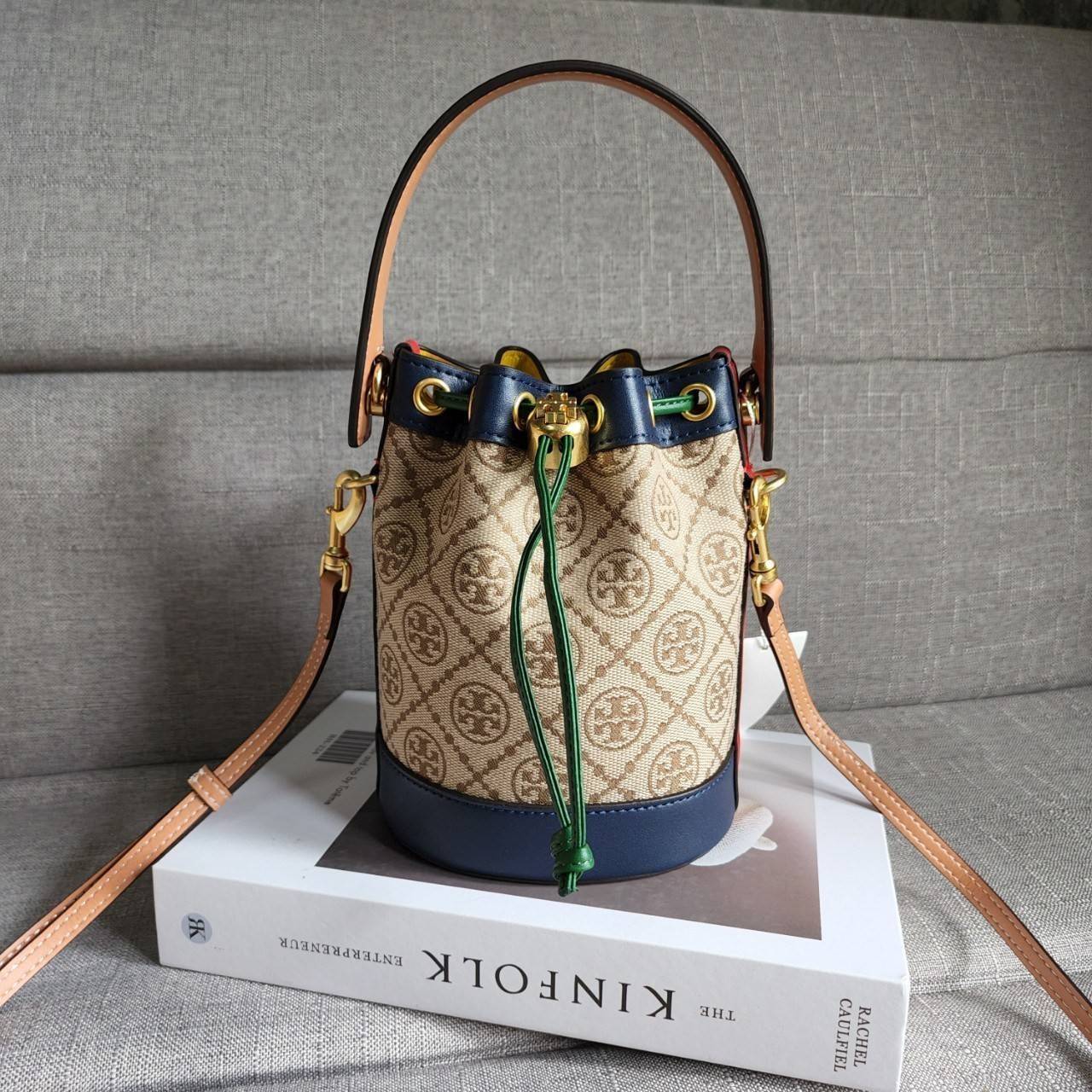 TORY BURCH T MONOGRAM COLORBlOCK JACQUARD MINI BUCKET BAG คอลเลคชั่นใหม่ล่าสุด ครอบครองก่อนใคร รุ่นบัคเก็ตทรงจีบ วัสดุ jacquard สลับหนังแท้ ตัดขอบข้างสีแดงทำให้ดูโดดเด่น หูจับหนังแท้ เปิด ปิด แบบหูรูด ภายในช่องโล่งกว้าง มาพร้อมสายสะพายข้างหนังแท้ ปรับระดั