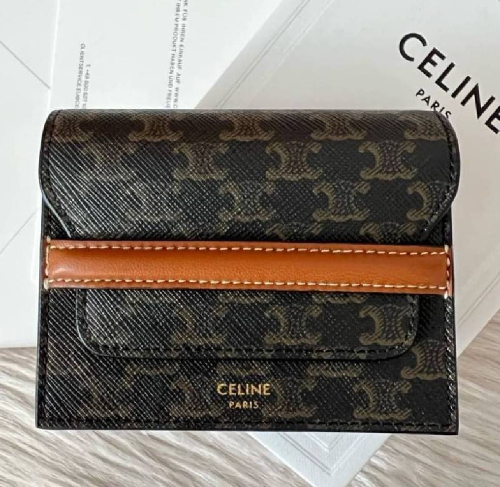 CELINE SHORT WALLET กระเป๋าสตางค์ซีลีนใบสั้น วัสดุ Triomphe Canvas หนังขึ้นลาย Signature Brand สวยอยู่ทรงมีโลโก้ด้านหน้าเปิดปิดด้วยฝาพับคาดเเถบหนังด้านหน้า ภายในมีโลโก้ มีช่องแบ่งหลายช่อง มีช่องใส่บัตรหลายช่อง สามารถช่องใส่เหรียญ บัตร ธนบัตรเเบบพับได้ ไอเ