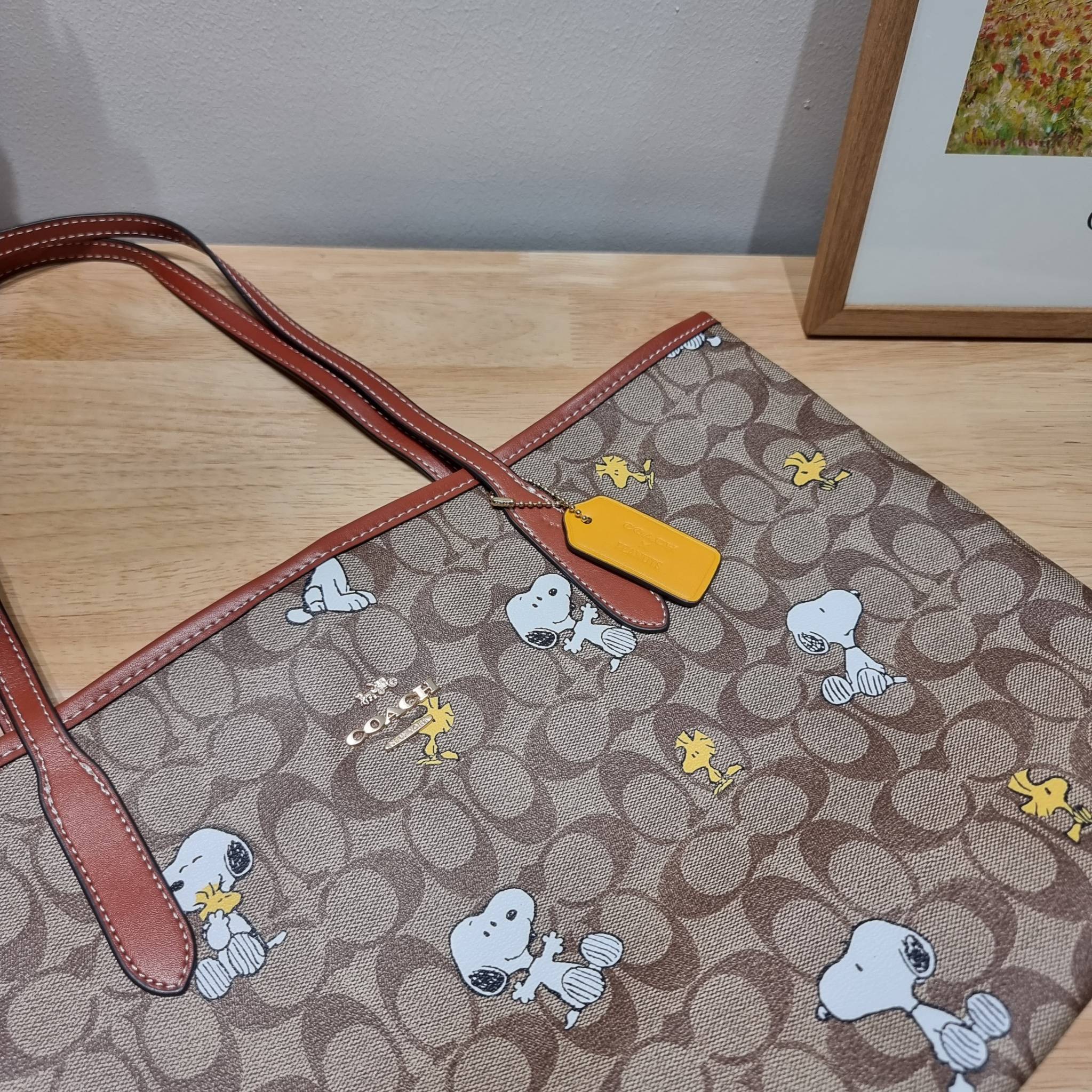 Coach X Peanuts City Tote In Signature Canvas With Snoopy Woodstock Print CF166 คอลเลคชั่นใหม่ น่ารักเกินต้าน กับกระเป๋าทรงโท้ทไซส์ใหญ่ ดีไซน์ลวดลายการ์ตูนยอดฮิต ที่ใครๆก็ต้องรู้จัก พิมพ์คมชัดลงบนหนังแคนวาส รูปทรงสวย ปากกระเป๋ามีกระดุมแม่เหล็กปิดกันของหล่