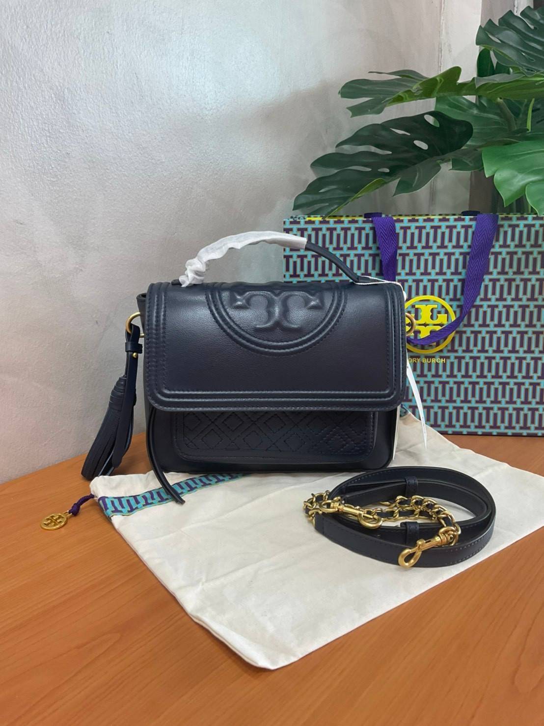 Tory Burch Fleming Satchel Bag รุ่น 45147 สี Royal Navy กระเป๋าสะพาย Crossbody ทรงสวย ดีไซน์เก๋ สุดคลาสสิค เพิ่มดีเทลโลโก้แบรนด์บนฝากระเป๋าอัพลุคให้ดูเท่ห์ และ พู่หนังถอดได้ วัสดุหนังแท้ สัมผัสนุ่มมือ หนังสวย น้ำหนักเบา ตั้งอยู่ทรง เปิดปิดด้วยกระดุมแม่เหล