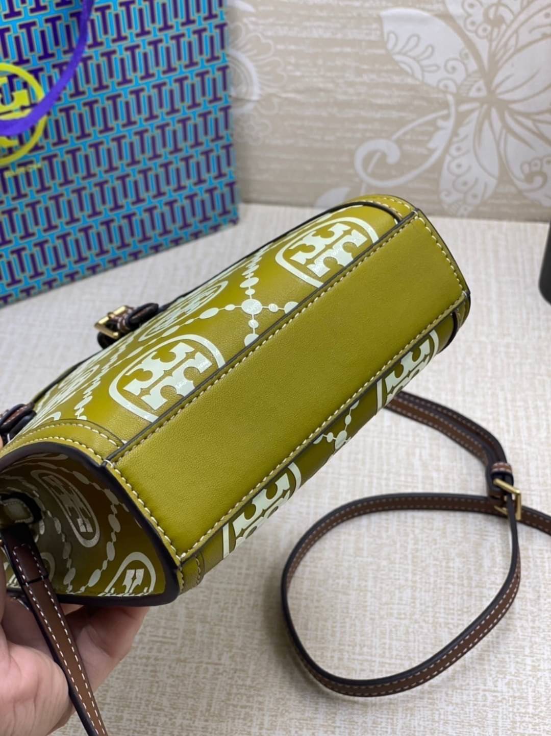 TORY BURCH T MONOGRAM EMBOSSED MINI TOTE สุดหรูกับกระเป๋าสะพายทรงโท้ท ไซส์มินิ ที่สร้างความหรูหราให้ตัวกระเป๋าด้วยดีเทลลายนูน แต่งแต้มลวดลายเอกลักษณ์ สีลูกคุณมากๆ!! วัสดุหนังแท้ ผิวสัมผัสดี ปากกระเป๋ามีแถบแม่เหล็กกันของหล่นได้ ภายในโล่ง ใส่ของจำเป็นได้ โท