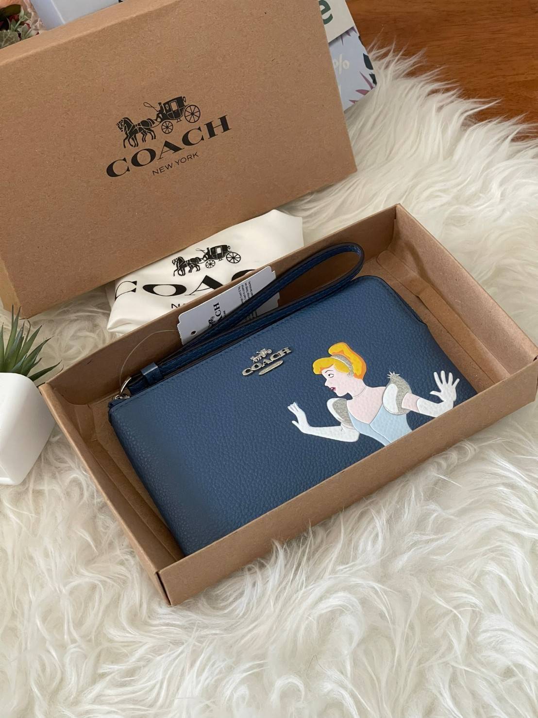 Coach & Disney Corner Zip Wristlet เปิดตัวคอลเลคชั่นเมื่อความดาร์กและโรแมนติกโคจรมาพบกัน เมื่อแบรนด์เครื่องหนังสัญชาติอเมริกัน Coach ร่วมมือกับ Disney สร้างสรรค์คอลเล็กชั่นพิเศษที่ได้รับแรงบันดาลใจมาจากเทพนิยายอเมริกันโกธิกของนิวยอร์ค ถ่ายทอดผ่านเหล่าตัวล