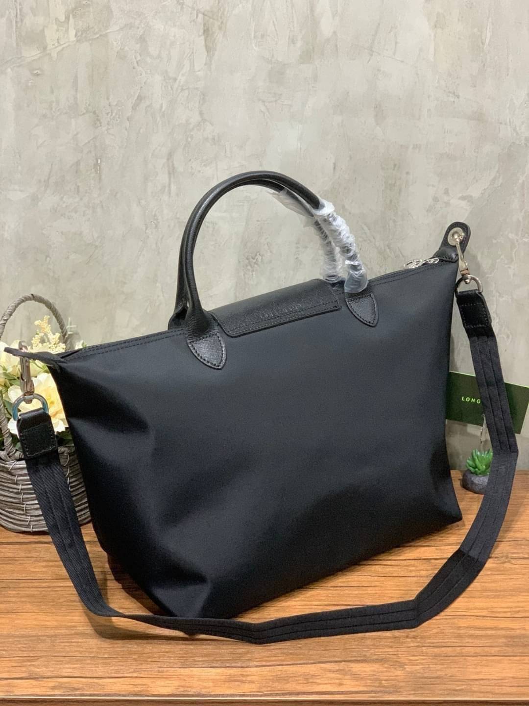 Longchamp Le Pliage Neo Size M มาพบกับกระเป๋ารุ่นยอดนิยม ที่สาวๆ ต้องมีไว้เก็บไว้สักใบ กระเป๋าโท้ทใบนี้ มาพร้อมกับสีที่มีสไตล์เรียบง่าย มีสายสะพายยาวช่วยให้คุณสามารถสะพายไหล่ได้อย่างสบาย ในขณะที่ที่ปิดแบบซิปช่วยให้คุณมั่นใจได้ว่าของด้านในมีความปลอดภัย Le 