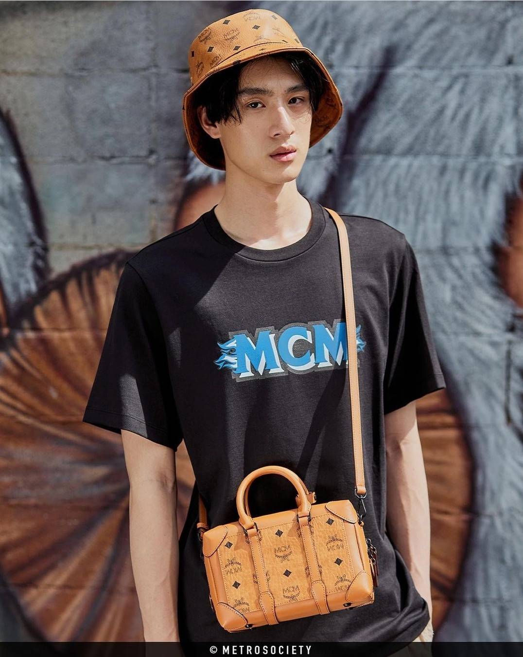 M.C.M SMALL E/W SOFT BERLIN CROSSBODY IN VISETOS ไอเท็มใหม่ในดีไซน์ทรงกระเป๋าเดินทางแบบคลาสสิค ย่อส่วนมาให้ใช้งานได้แบบสบายๆ พกพาสะดวก แมทช์ได้ทุกสไตล์ ใช้ได้แบบ unisex ใช้งานง่ายด้วยหูจับในตัว และซิปหลัก อะไหล่สีดำดูมีมิติตัดกับสีน้ำตาลคอนยัคได้เป็นอย่าง