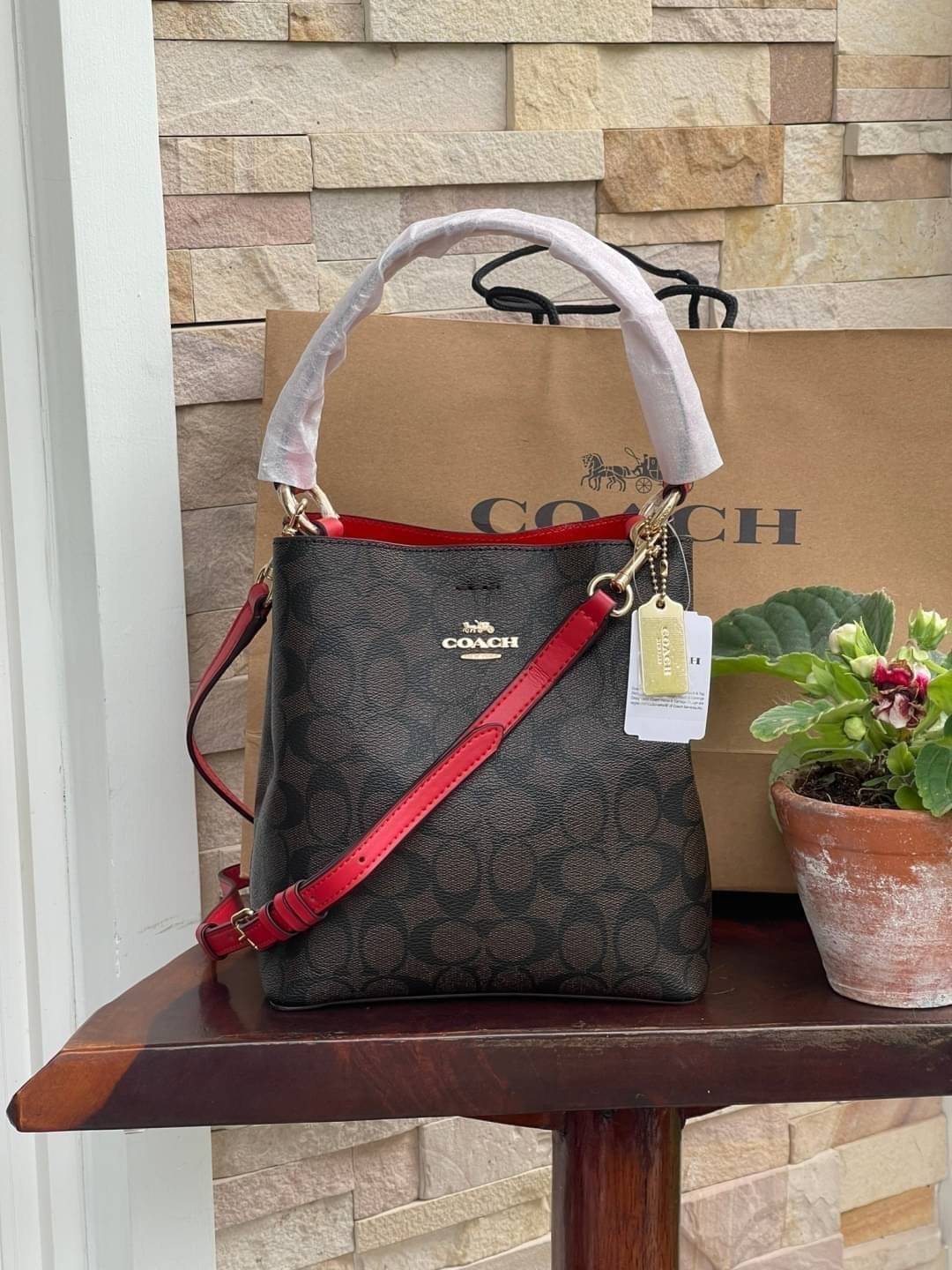 COACH SMALL TOWN BUCKET BAG IN SIGNATURE สำหรับสาวแฟชั่นที่ชอบรายละเอียดชิคๆ ดีไซน์สุดเก๋ แนะนำเลยสำหรับกระเป๋าทรงบักเก็ตใบนี้ เชื่อว่าสาว ๆ หลายคนชื่นชอบ เป็นไอเทมที่สามารถแมทช์ได้กับเสื้อหลากหลายสไตล์ บรรจุของได้เยอะโดยที่กระเป๋าไม่เสียทรง แบ่งช่องใช้งา