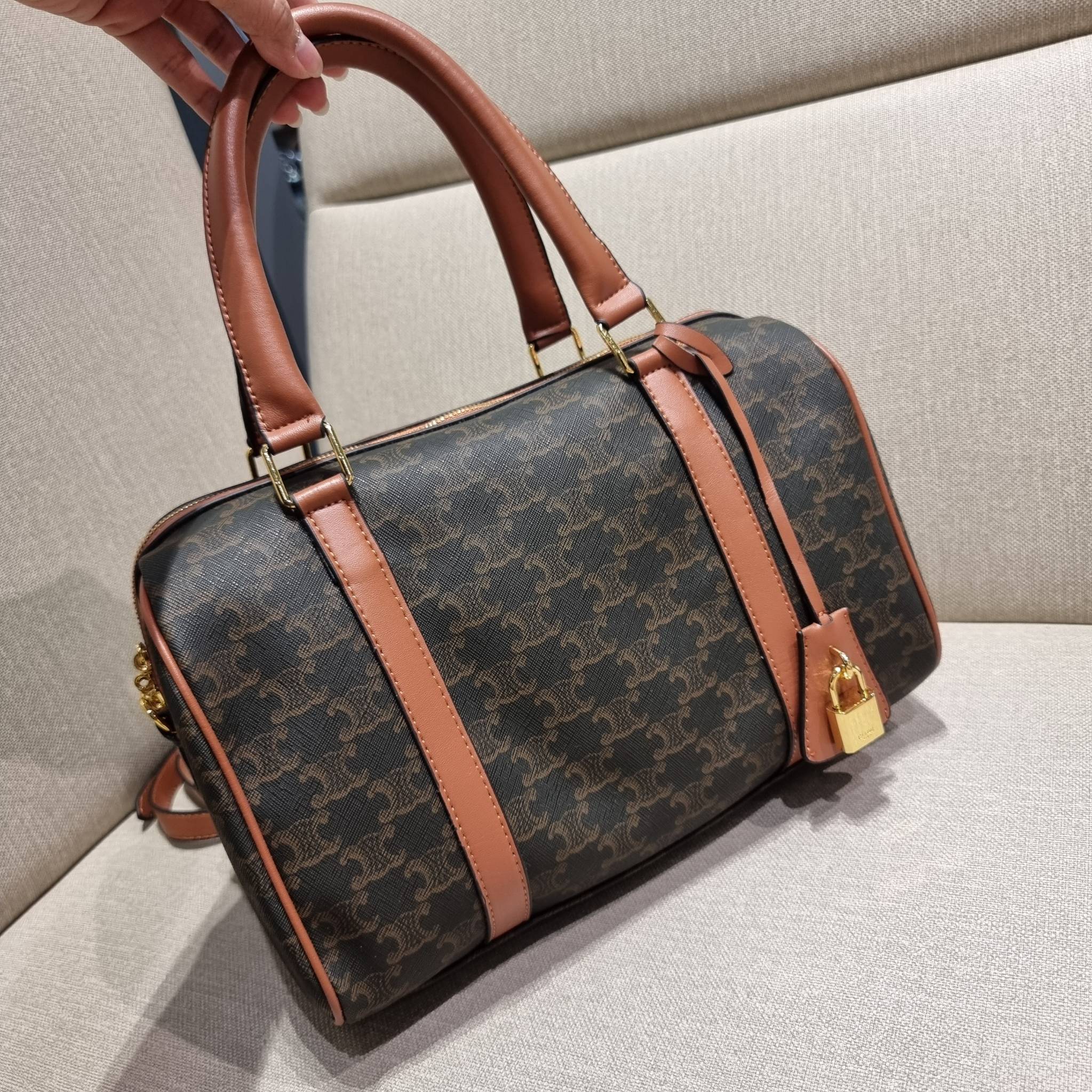 CELINE BOSTON BAG IN TRIOMPHE CANVAS AND CALFSKIN ยอดฮิตกับลวดลายเอกลักษณ์ สุดคลาสสิค กับกระเป๋ากึ่งเดินทาง ไซส์กำลังดี ที่สามารถใช้ได้ทั้งหนุ่มๆและสาวๆ วัสดุหนังแคนวาสตัดสลับหนังแท้ เปิด-ปิดด้วยซิป ใช้งานสะดวก และยังมีพวงหนังห้อยและแม่กุญแจล็อคซิปได้ มาพ