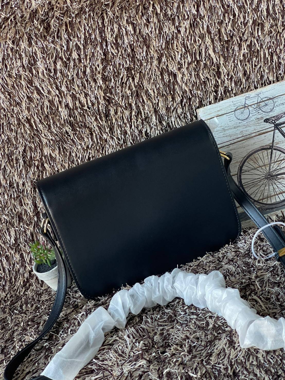 Celine MEDIUM TRIOMPHE BAG IN SHINY มีรูปทรงเป็นกล่องคล้ายกับกระเป๋า Classic Box แต่มีการออกแบบโลโก้ที่สะดุดตาแบบวินเทจ ด้วยดีไซน์ที่ดูโฉบเฉี่ยว แต่คงความคลาสสิคอย่างเต็มเปี่ยม ทำให้เป็นที่ดึงดูดความสนใจของสาวๆ สายสะพายสามารถปรับระดับได้ มีความคล่องตัวในก