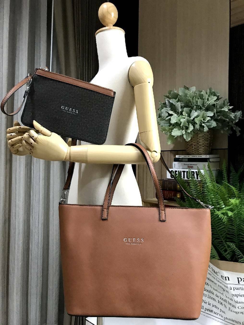 GUESS LARGE SHOPPER BAG WITH POUCH กระเป๋าสะพายรุ่นใหม่ล่าสุดจาก GUESS FACTORY หนัง Saffiano สวยหรูอยู่ทรง ด้านหน้ามีโลโก้แบรนด์ ด้านหลังมีช่องใส่ของ หูหิ้วสะพายไหล่ได้มาพร้อมสายสะพายยาวถอดได้ปรับได้ มีกระเป๋าใบเล็กเข้าชุดกันห้อยที่หูหิ้ว ใบเล็กถอดเเยกใช้
