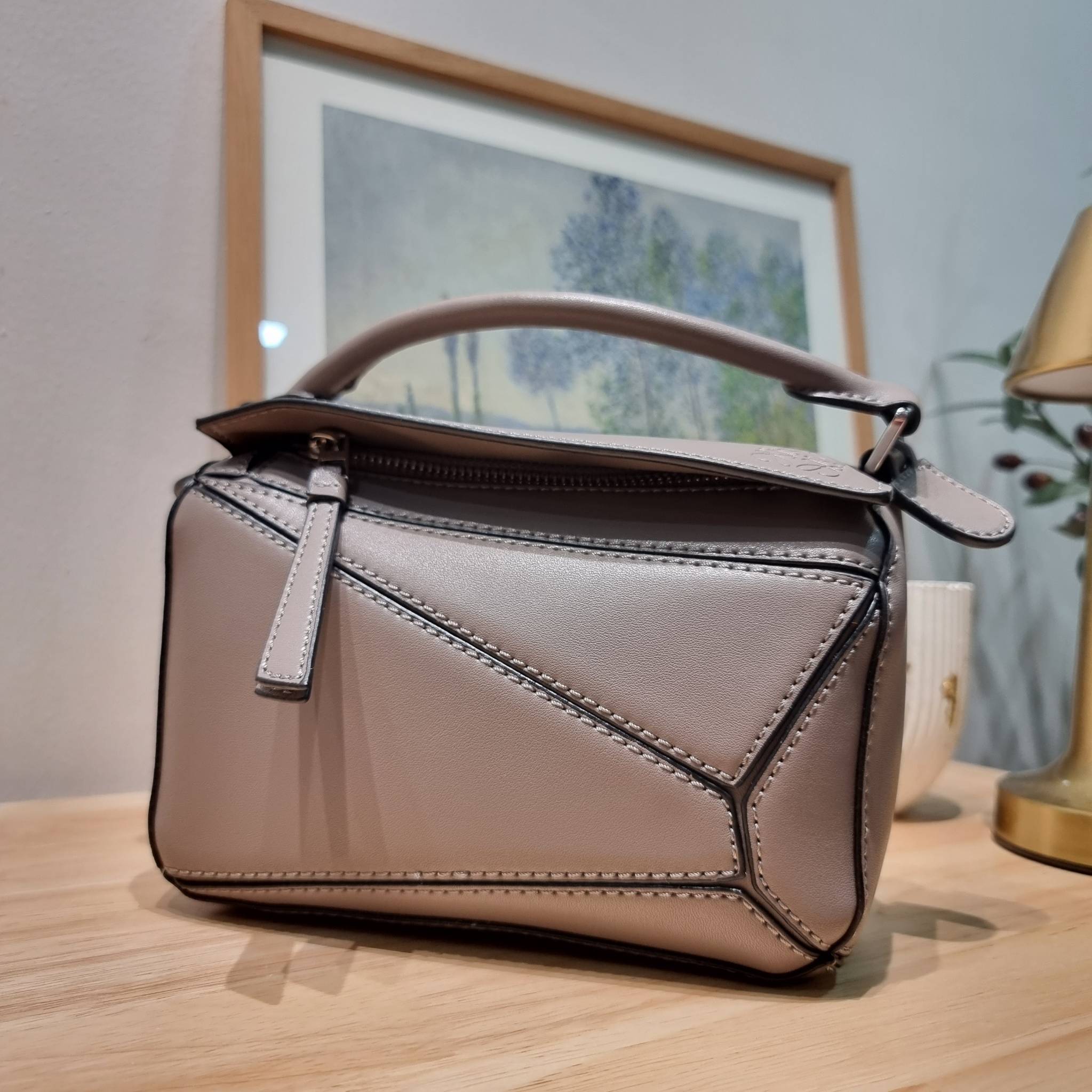 LOEWE MINI PUZZLE BAG IN CLASSIC สุดยอดแบรนด์ที่ดีไซน์เป็นเอกลักษณ์ โดดเด่น สวยหรู กับกระเป๋าสะพายข้างทรงกล่อง ไซส์มินิ สไตล์พัซเซิล ให้ฟีลลิ่งเหมือนตัวต่อคละสี ดูดีได้ทุกที่แค่มีใบนี้