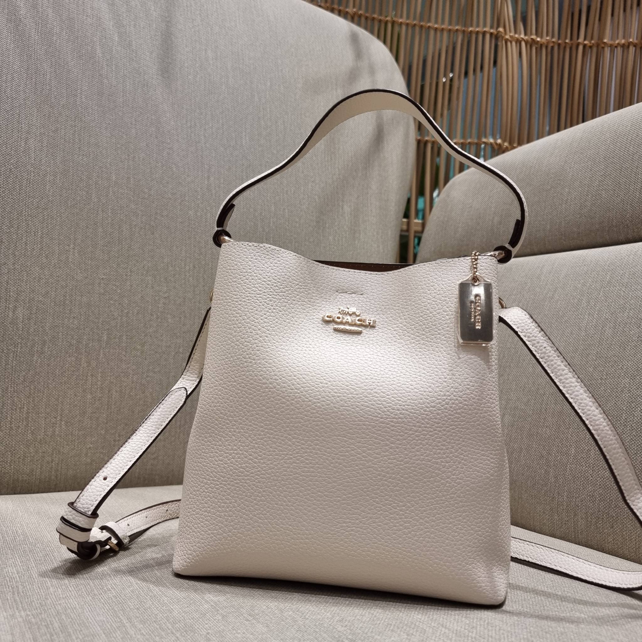 COACH 1011 SMALL TOWN BUCKET BAG รุ่นยอดนิยมใบเล็ก กระเป๋าทรงบัคเก็ต สีคลาสสิคเรียบหรู ตัดกับโลโก้สีทองดูโดดเด่น วัสดุหนัง pepble สวยคมทุกมุมจริงๆ!! เปิด-ปิดด้วยกระดุมแม่เหล็กทั้ง 2 ฝั่ง ภายในเป็นช่องโล่ง มาพร้อมสายสะพายปรับได้ตามตัว ขนาดใบนี้กำลังสวย สะพ