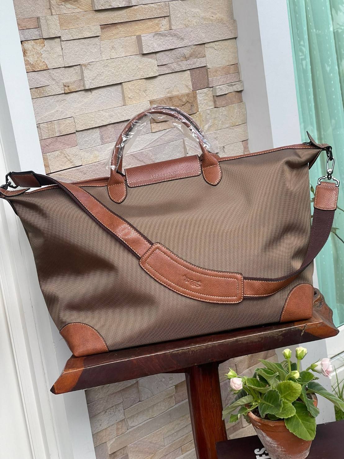 LONGCHAMP BOXFORD TRAVEL BAG L กระเป๋าเดินทางขนาดใหญ่ มาพร้อมสายสะพายที่สามารถถอดได้ ให้คุณเลือกสะพายไหล่หรือถือได้ มีซิปรูดเปิดปิดกระเป๋าที่ให้คุณมั่นใจได้ว่าคุณจัดเก็บไอเท็มของคุณได้อย่างมิดชิด บ็อคฟอร์ด (BOXFORD) สะท้อนความเป็นเอกลักษณ์ของแบรนด์ที่เปี่