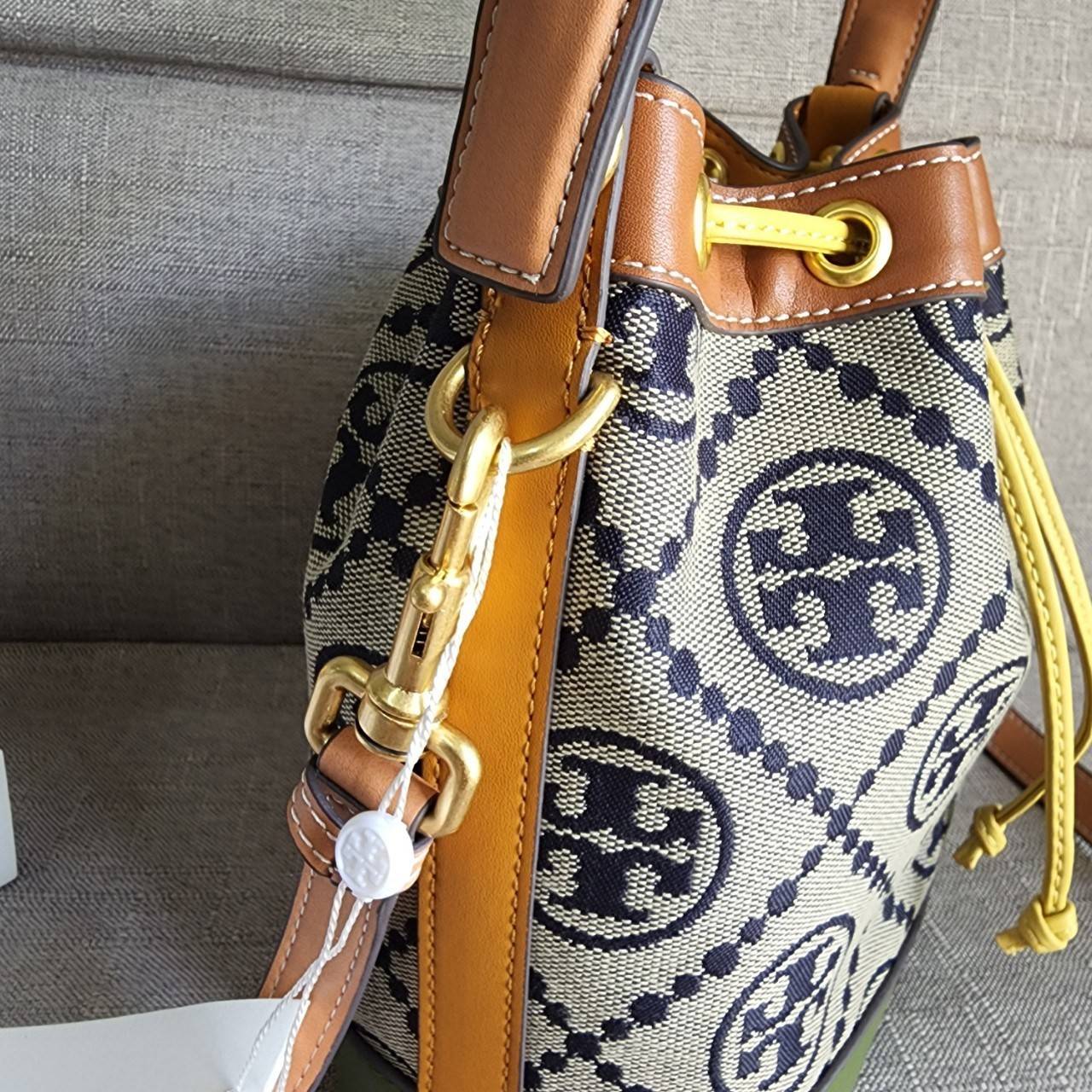 Tory Burch T Monogram Colorblock Bucket Bag กระเป๋าสะพาย ทรงบัคเกต รุ่นฮอต สไตล์ไหนเข้าได้ทุกลุค วัสดุ jacquard ตัดขอบหนังแท้ ภายในเป็นช่องโล่งกว้าง ใส่ของได้เยอะหยิบจับสะดวก มาพร้อมสายสะพายข้างหนังแท้ ถอดและปรับระดับได้สะพายชิวได้ทุกโอกาส