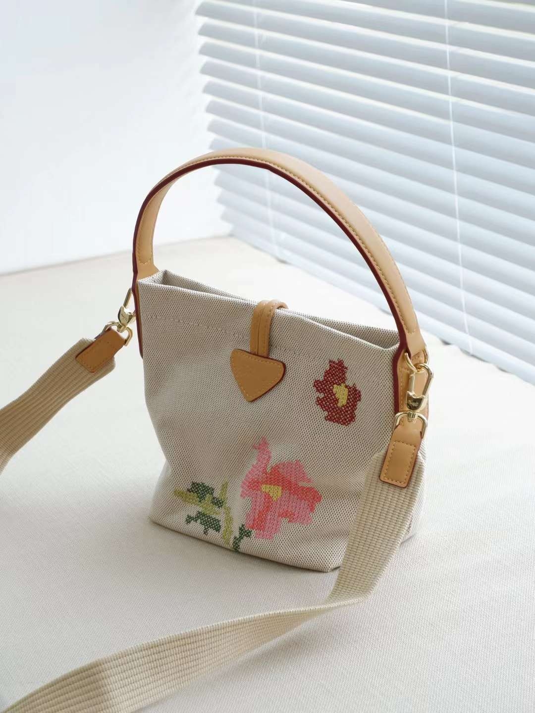 LONGCHAMP ROSEAU ESSENTIAL FLEURS Bucket bag S - กระเป๋าทรงถังขนาดเล็ก วัสดุผ้าฝ้าย ลายปักษ์ดอกกุหลาบ Roseau เป็นคอลเล็คชั่นที่สดใสและเรียบง่าย ซับในสีพื้น อะไหล่สีทอง น้ำหนักเบา จุของได้เยอะ มีสายสะพายไล่ ถอดสายได้ Crossbody ได้