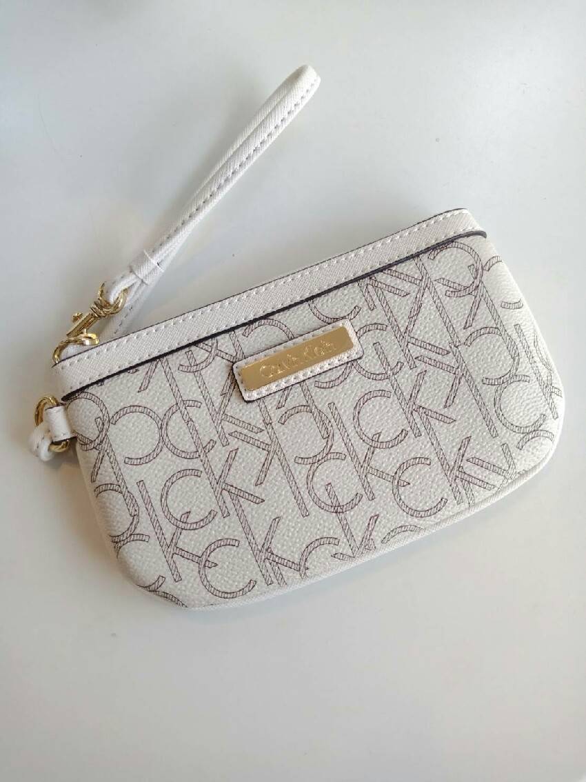 New must have item! กระเป๋าคล้องมือ ทรงน่ารัก จากแบรนด์ calvin klein มีมาให้ช้อปคะ หนัง pvc ทั้งใบอย่างดี มีสายคล้องมือเก๋ ด้านหน้าตกแต่งด้วยโลหะปั้มแบรนด์ เปิดปิดด้วยซิป ด้านในบุด้วยผ้าปั้มแบรนด์ มีช่องใส่บัตรแยก จะใส่ธนบัตรหรือบัตร ก็พกติดตัวในวันสบายๆ