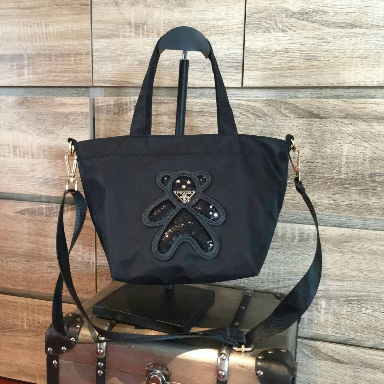 Restock! must have now!! สำหรับกระเป๋าอเนกประสงค์ ทรง MiniTOTE จากแบรนด์ PRADA เป็น กระเป๋าผ้าไนล่อน ตามแบบฉบับของแบรนด์เลย ใบนี้มีสายยาวให้ค่ะ เลิศมาก สะพายเป็น shoulder bag หรือ ถือได้คะ ด้านหน้าเป็นลายหมี ปั๊กกลิ้ตเตอร์ + logo brand ใช้แล้วสวยมากๆ อะไห